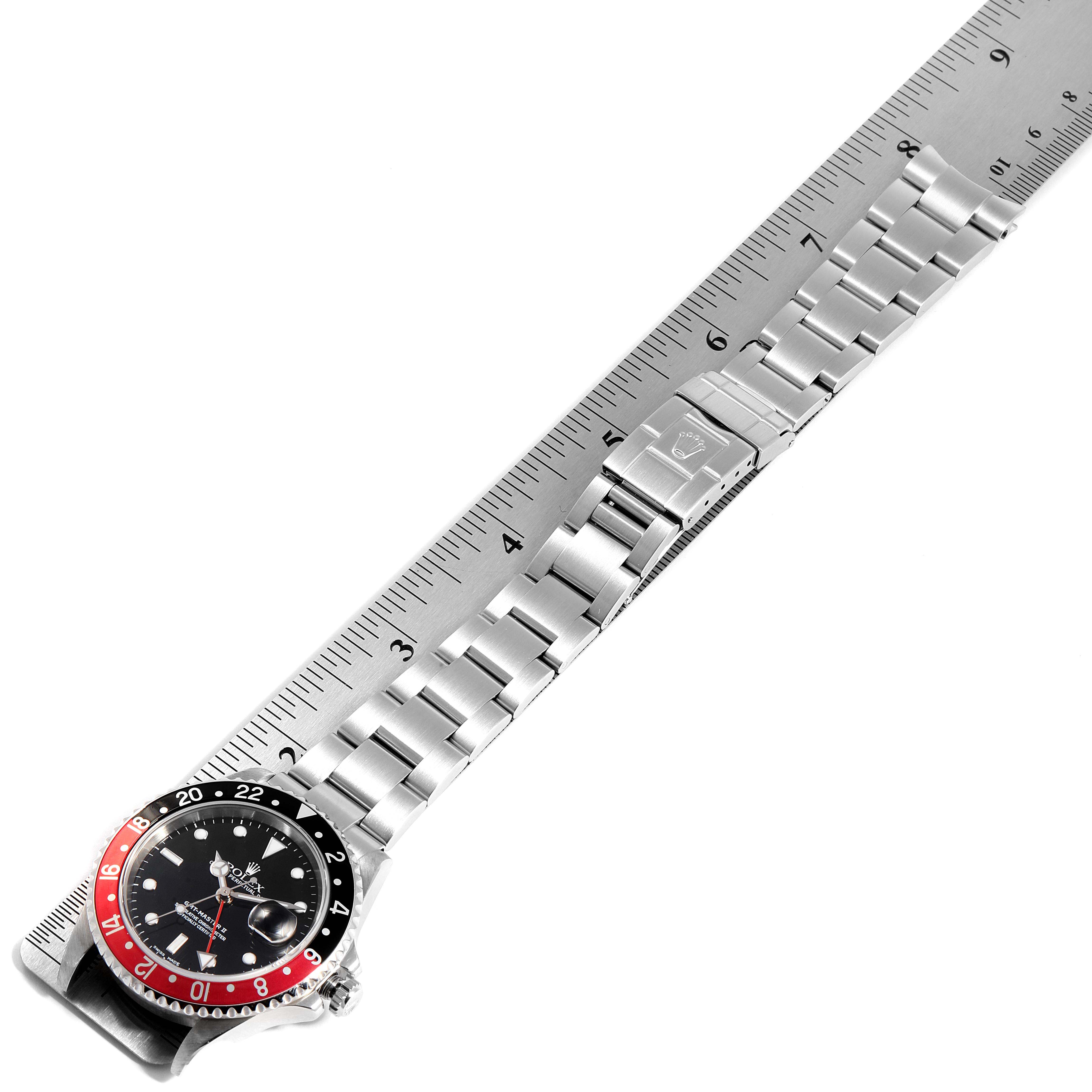 The image shows a top-down view of a Rolex GMT-Master 16710 Men
s Stainless Steel Black Dial 16710 Men
s Stainless Steel Black Dial watch, displaying its bezel, dial, and bracelet against a measuring ruler.