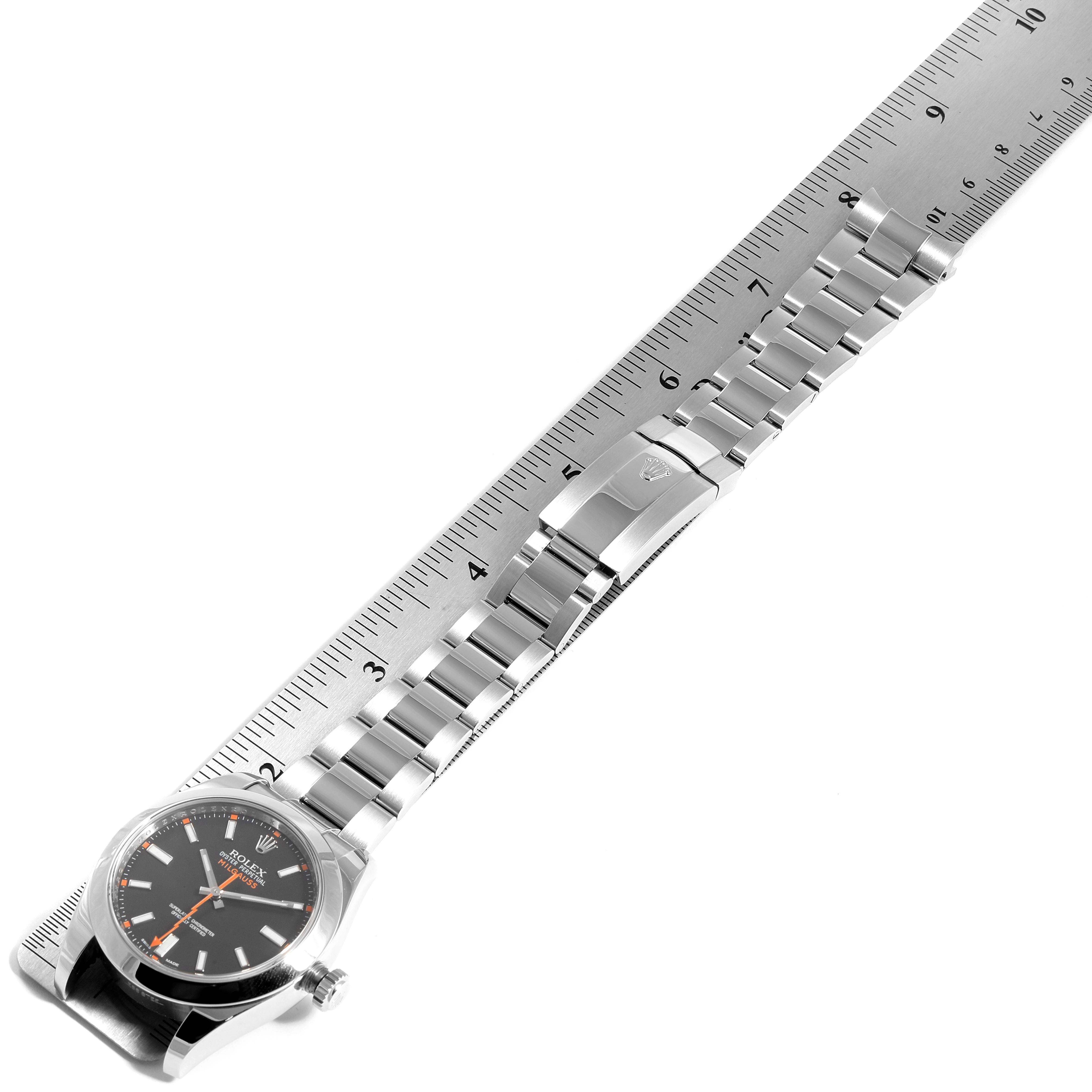 The Rolex Milgauss 116400 Men's Stainless Steel Black Dial 116400 Men's Stainless Steel Black Dial watch is shown from a top-down angle, highlighting the face, bracelet, and clasp along a ruler for measurement.