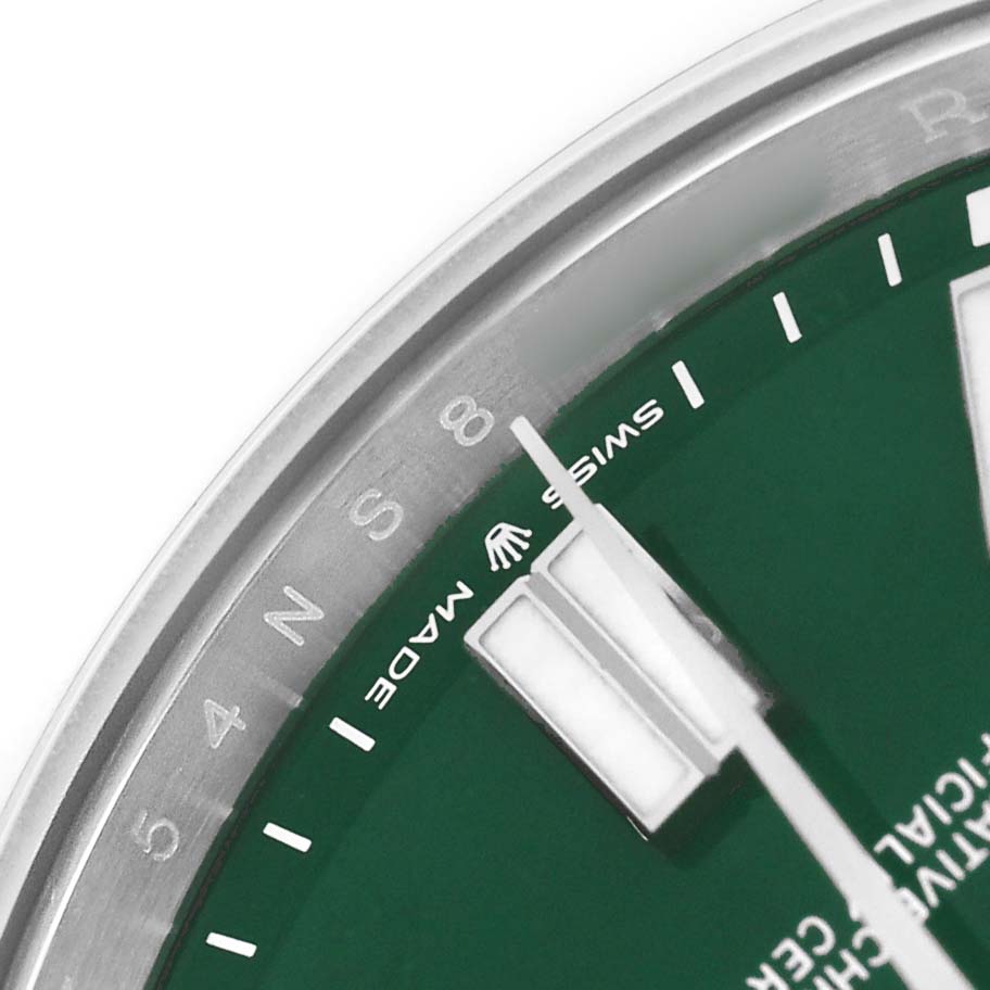 The image shows a close-up of the dial and bezel of a Rolex Oyster Perpetual M124300-0005 Men's Stainless Steel Green Dial watch at an angle, highlighting the hour markers and "Swiss Made" text.