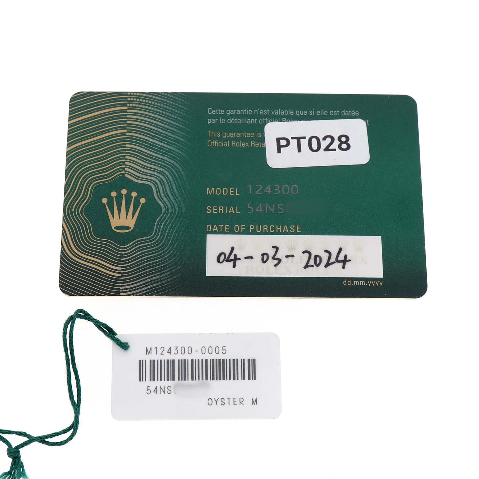 The image shows a Rolex Oyster Perpetual M124300-0005 Men's Stainless Steel Green Dial model warranty card and a tag with model and serial numbers.