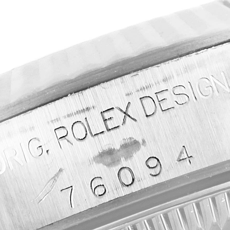 The image shows a close-up of the engraved case side of a Rolex Oyster Perpetual 76094 Women's Stainless Steel Pink Dial 76094 Women's Stainless Steel Pink Dial watch, featuring the text "ORIG. ROLEX DESIGN" and the model number.