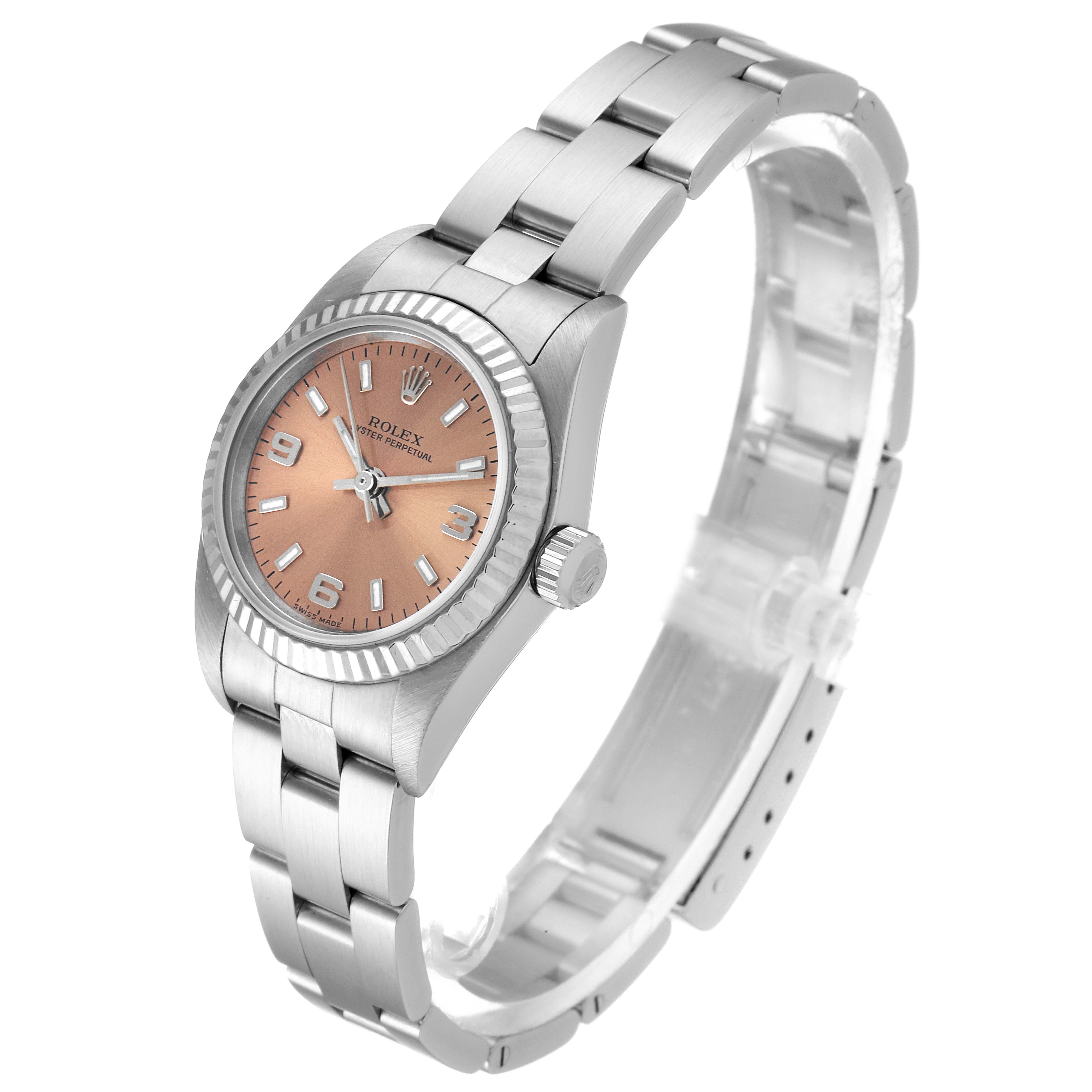 The Rolex Oyster Perpetual 76094 Women's Stainless Steel Pink Dial 76094 Women's Stainless Steel Pink Dial watch is shown at an angled view, highlighting the face, bezel, case, and bracelet.