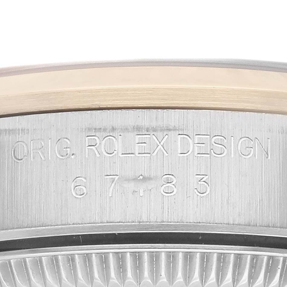 This image shows a close-up view of the side of the Rolex Oyster Perpetual 67183 Women's Steel and Gold (two tone) Grey Dial 67183 Women's Steel and Gold (two tone) Grey Dial watch, highlighting the engraved text and part of the bezel.