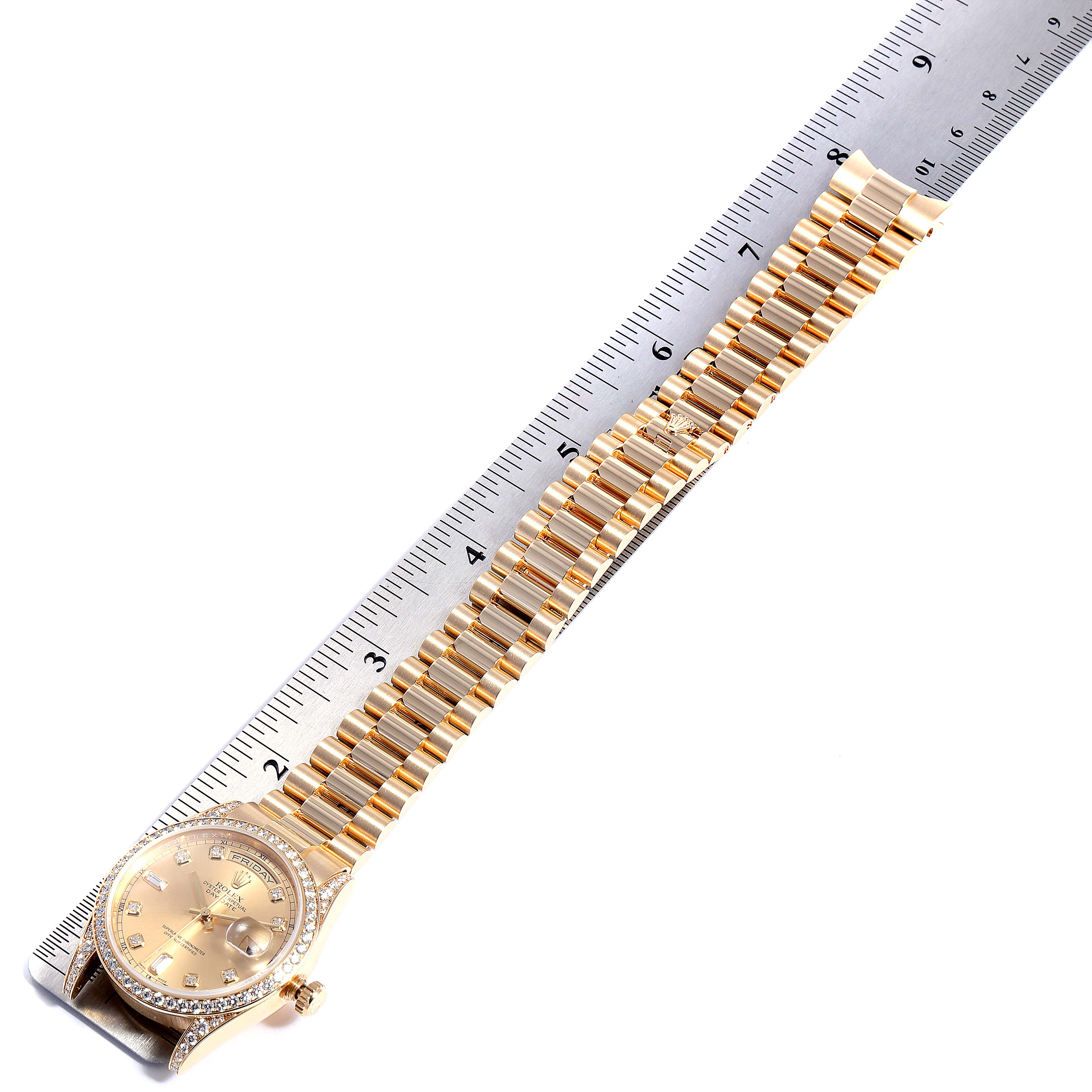 This image shows a gold Rolex President 118388 Men
s Yellow Gold Champagne Dial 118388 Men
s Yellow Gold Champagne Dial model watch, laid flat next to a ruler, displaying the watch face and full bracelet.