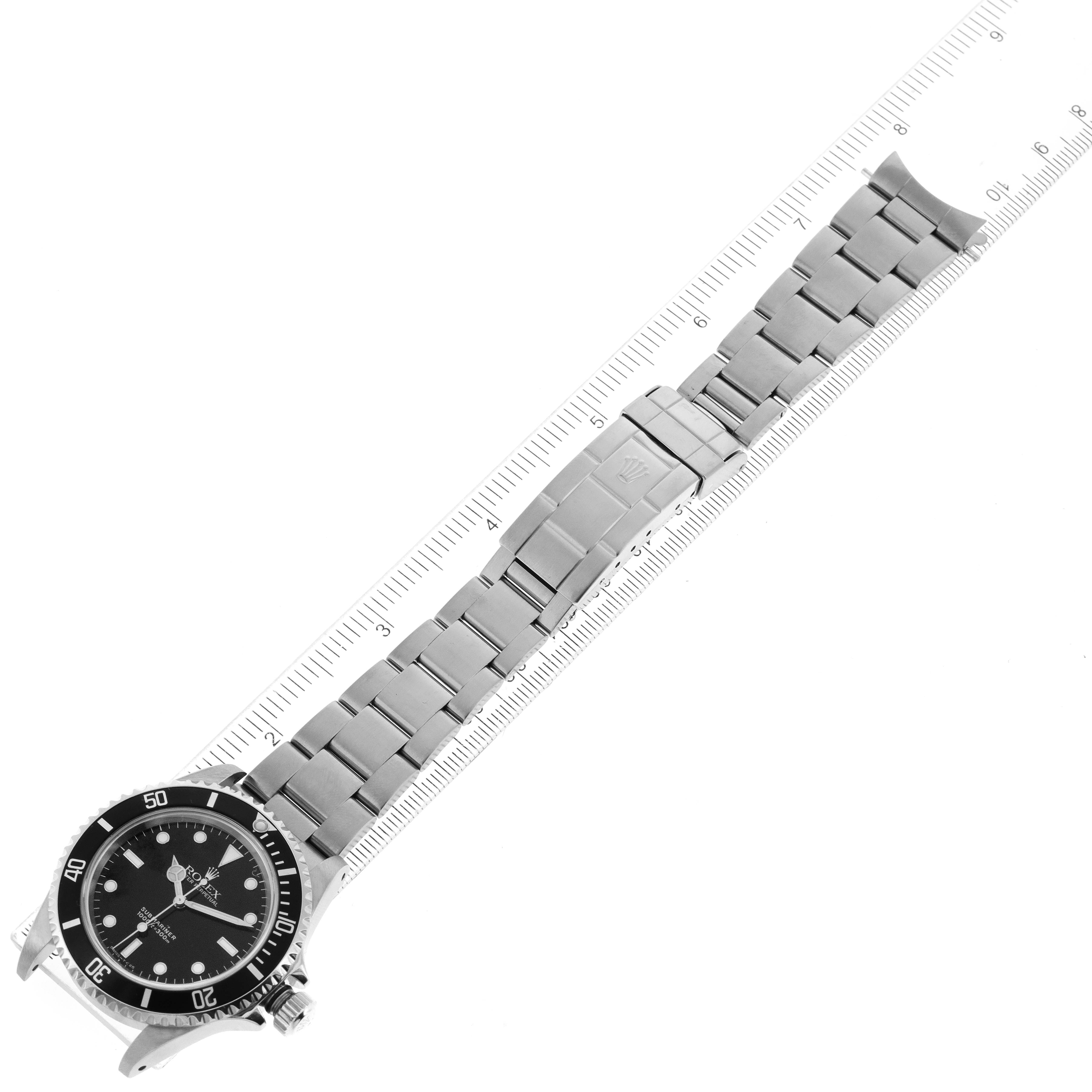 The image shows a top view of a Rolex Submariner 14060 Men
s Stainless Steel Black Dial 14060 Men
s Stainless Steel Black Dial watch with its bracelet laid out and measured with a ruler.