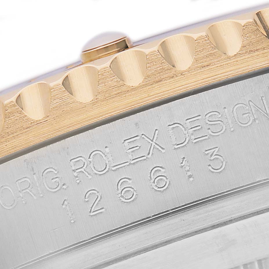 The image shows a close-up angle of the Rolex Submariner 126613 Men's Steel and Gold (two tone) Blue Dial's bezel and engraved side, featuring the model number.