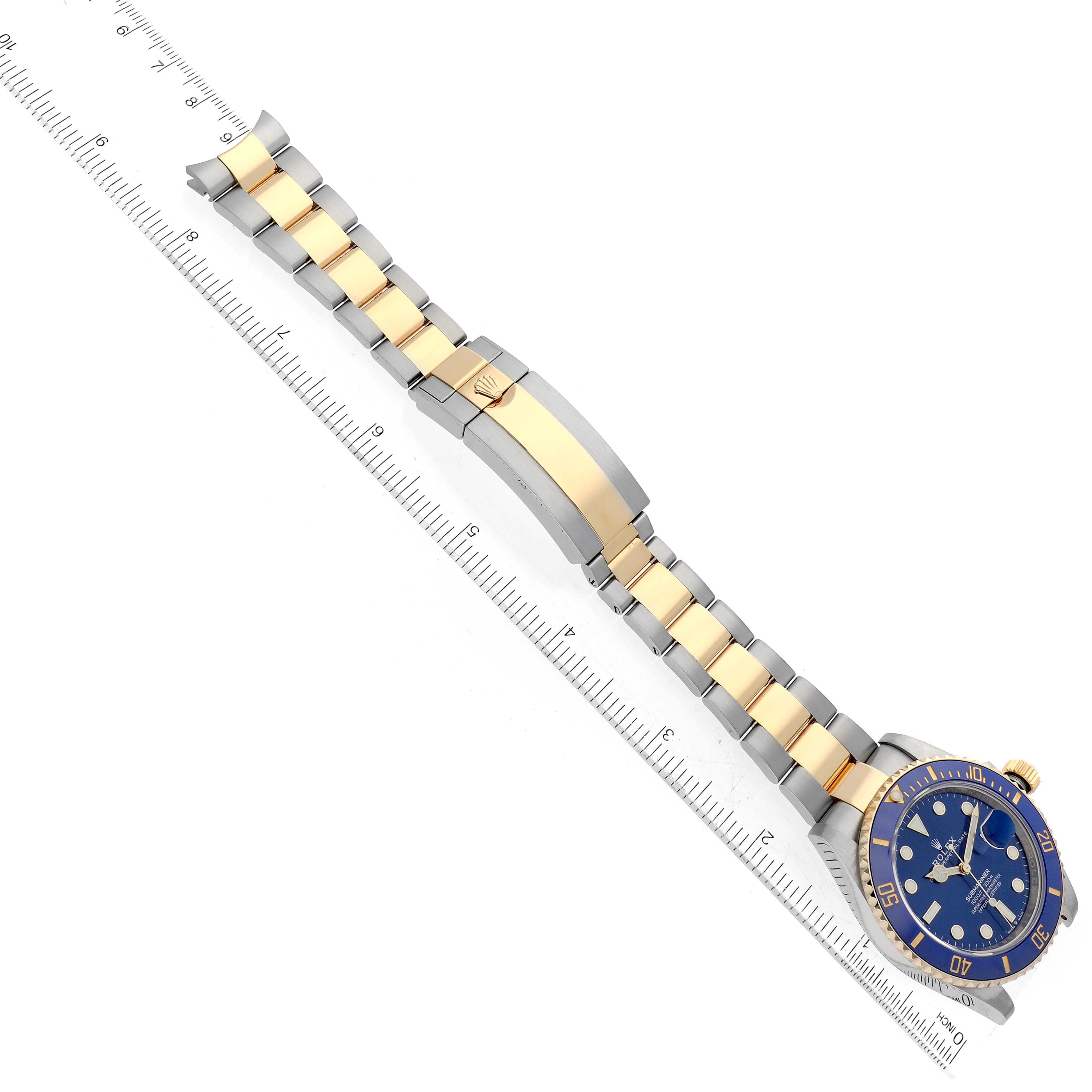 This image shows a Rolex Submariner 126613 Men's Steel and Gold (two tone) Blue Dial 126613 Men's Steel and Gold (two tone) Blue Dial watch laid flat, with its strap fully extended along a measuring ruler.