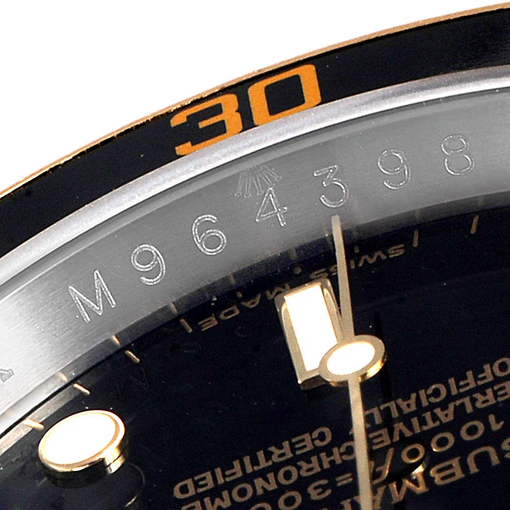 This close-up image shows the bezel, partial dial, and engraved serial number of a Rolex Submariner 16613 Men's Steel and Gold (two tone) Black Dial 16613 Men's Steel and Gold (two tone) Black Dial watch.
