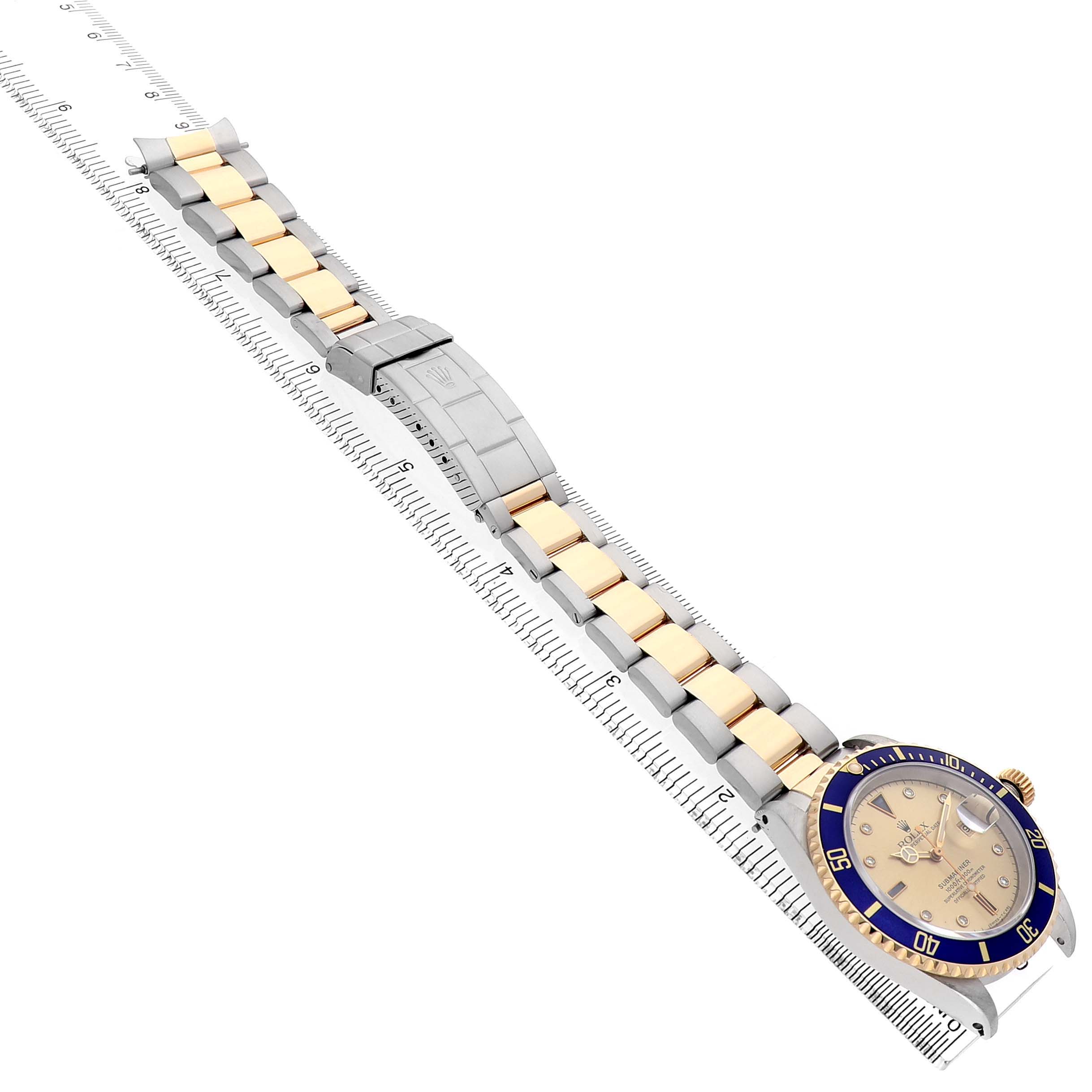 The Rolex Submariner 16613 Men's Steel and Gold (two tone) Champagne Dial watch is shown at an angle highlighting its face, bezel, and entire bracelet laid out, including the clasp.