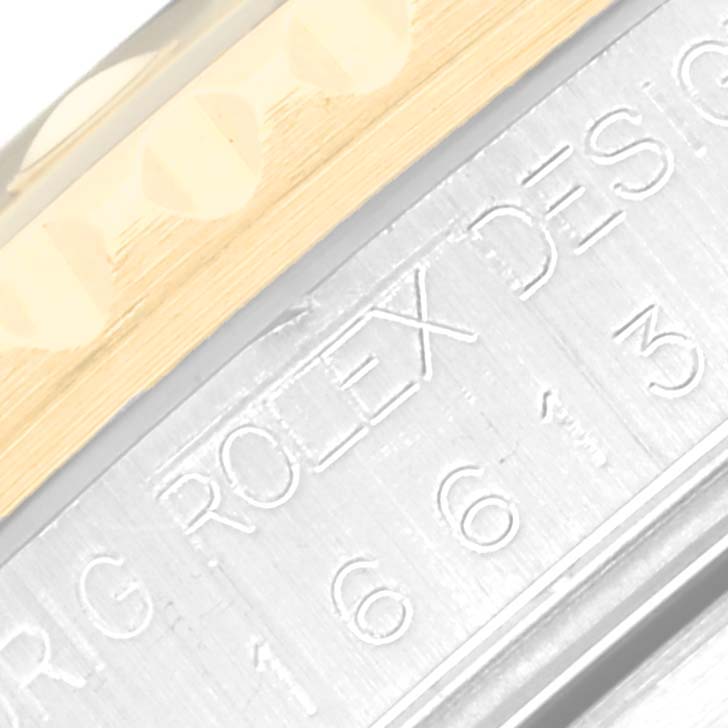 This close-up of a Rolex Submariner 16613 Men's Steel and Gold (two tone) Blue Dial 16613 Men's Steel and Gold (two tone) Blue Dial watch shows a portion of the bezel and engravings on the case side.