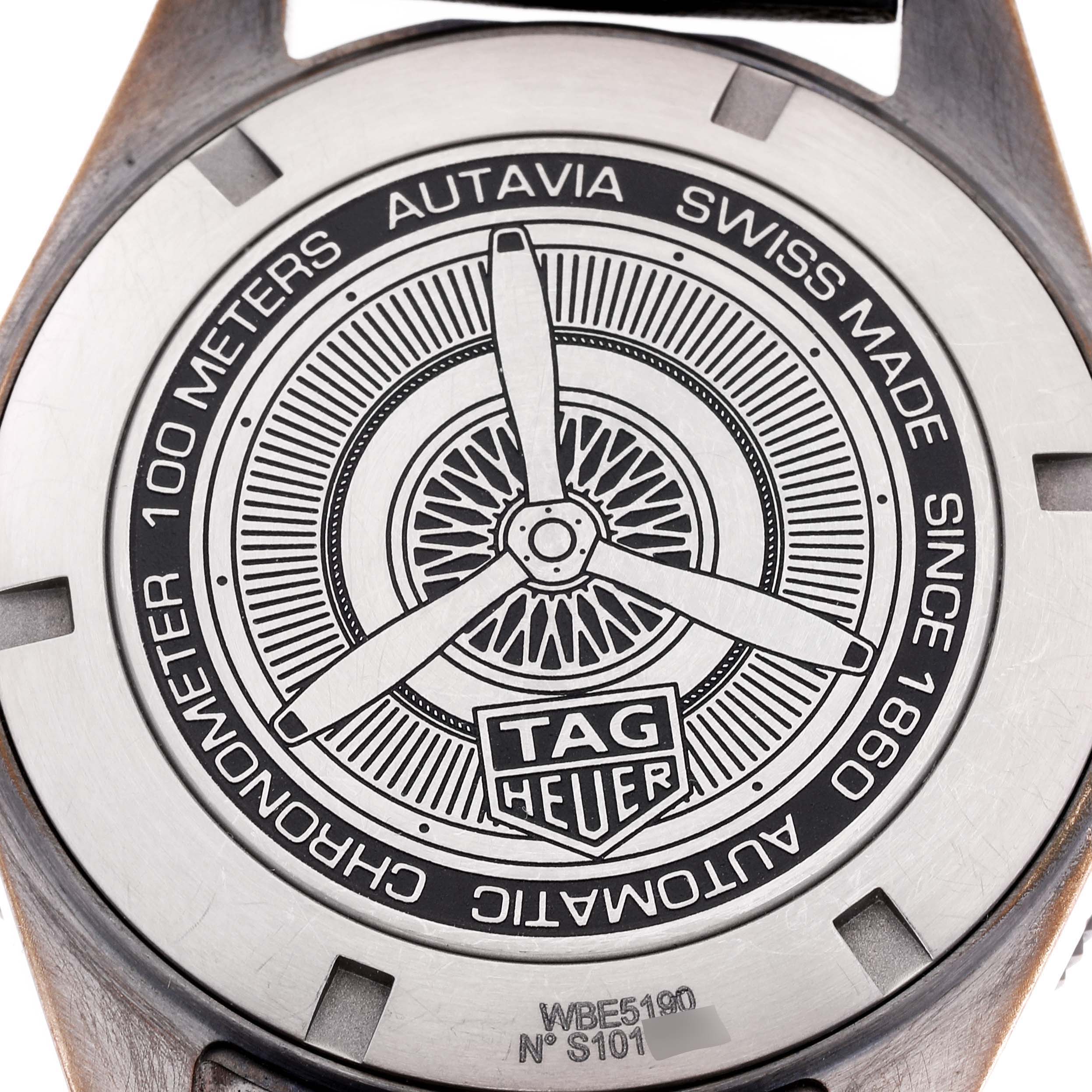 This image shows the back of a Tag Heuer Autavia WBE5190.FC8268 Men's Bronze Green Dial WBE5190.FC8268 Men's Bronze Green Dial watch, featuring an engraved rotor design and branding details.