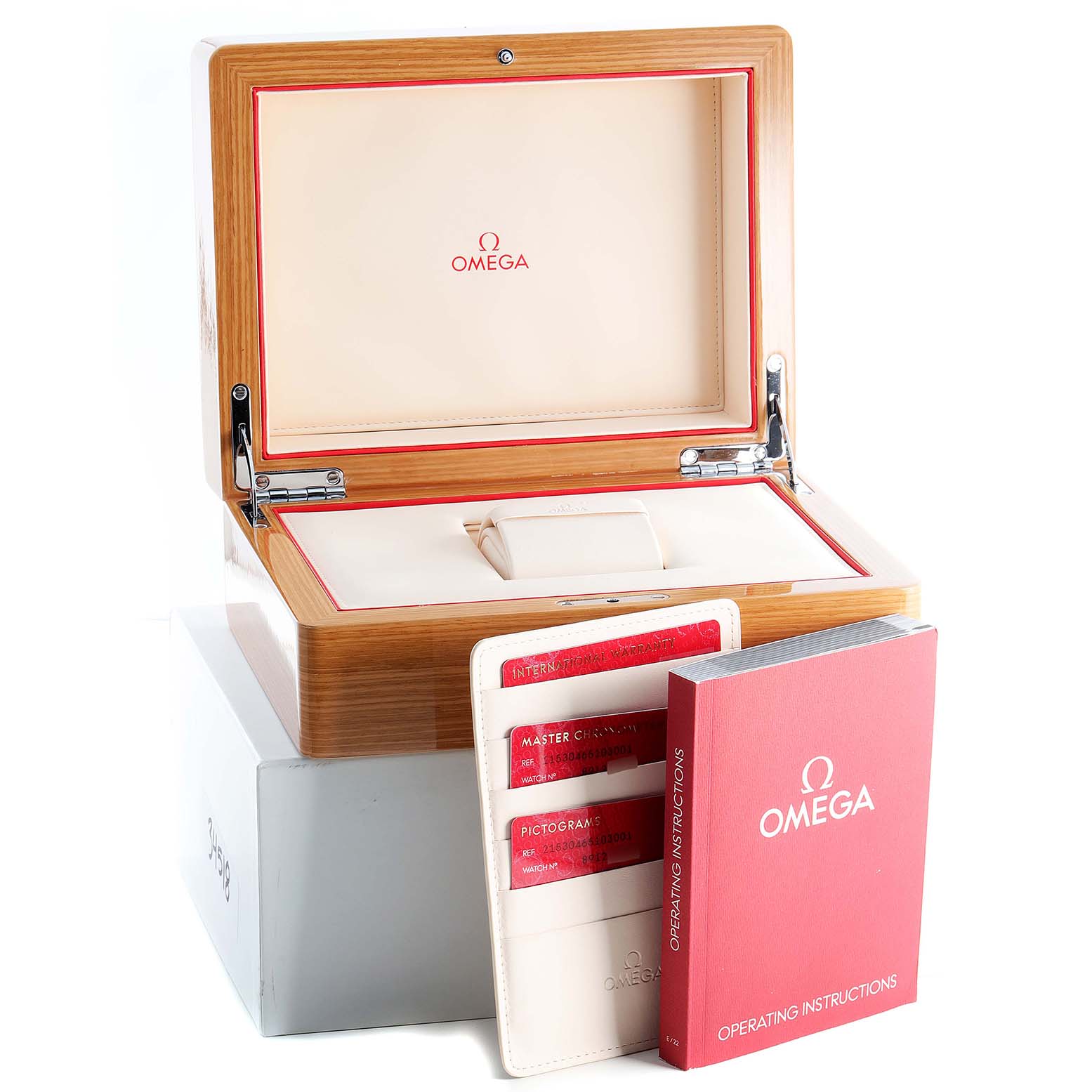 The image shows an open Omega wooden watch box, with the Planet Ocean model's operating instructions and cards displayed in front.