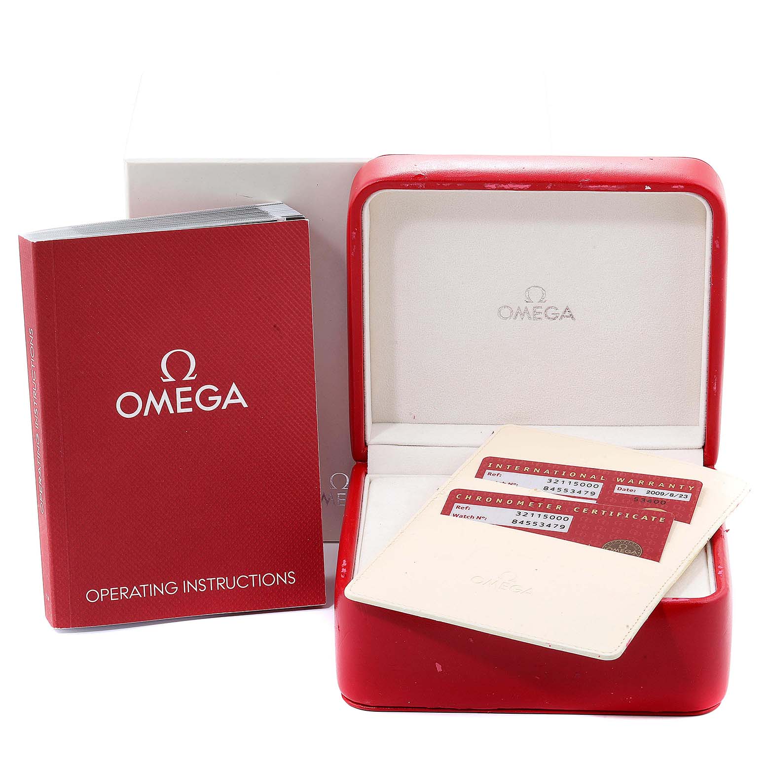 The image shows an Omega Speedmaster 3211.50.00 Men
s Stainless Steel Black Dial 3211.50.00 Men
s Stainless Steel Black Dial watch box, operating instructions, and warranty cards on a flat surface.