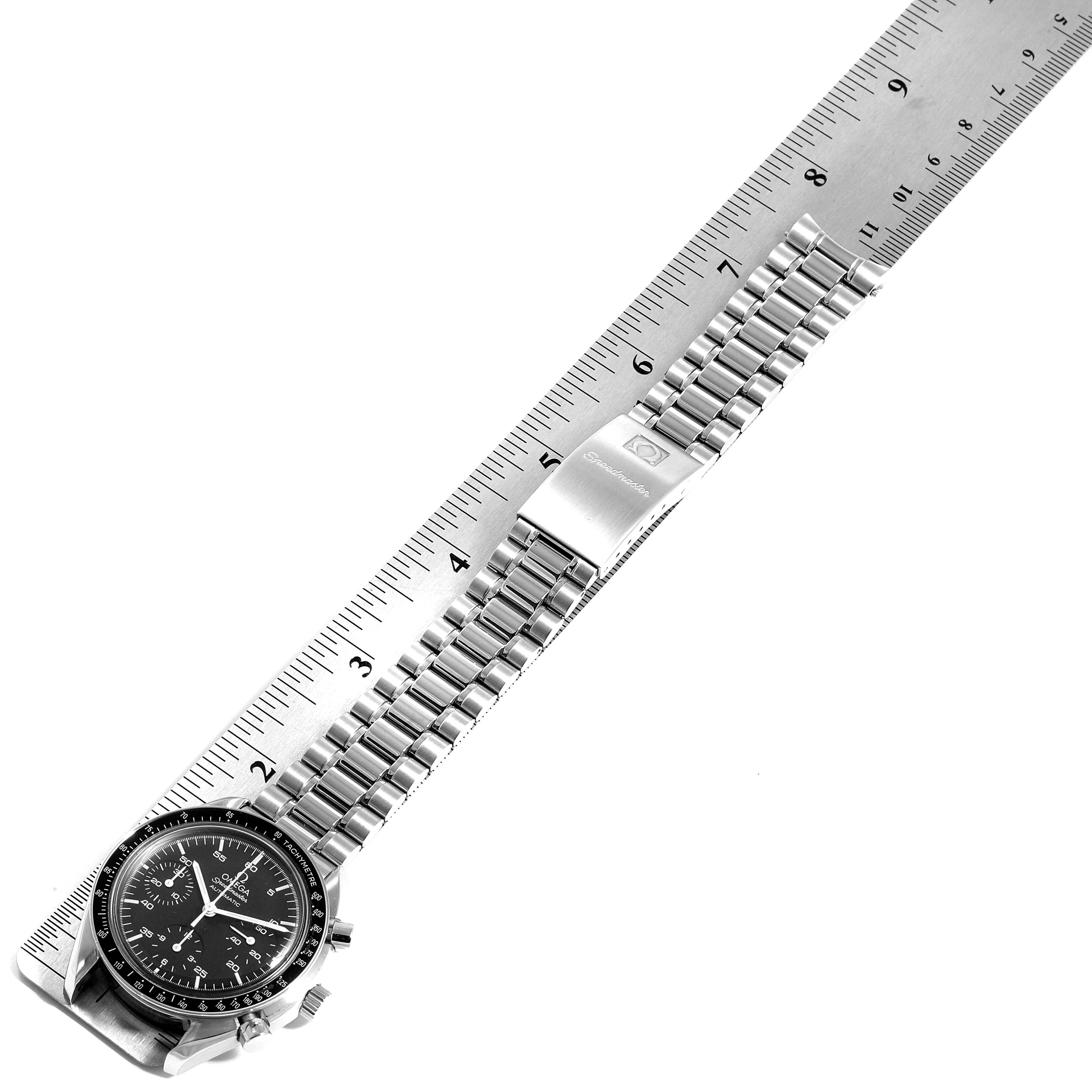 This image shows the Omega Speedmaster 3510.50.00 Men
s Stainless Steel Black Dial 3510.50.00 Men
s Stainless Steel Black Dial watch laid on a ruler, highlighting the watch face, bracelet, and clasp from an angled side view.
