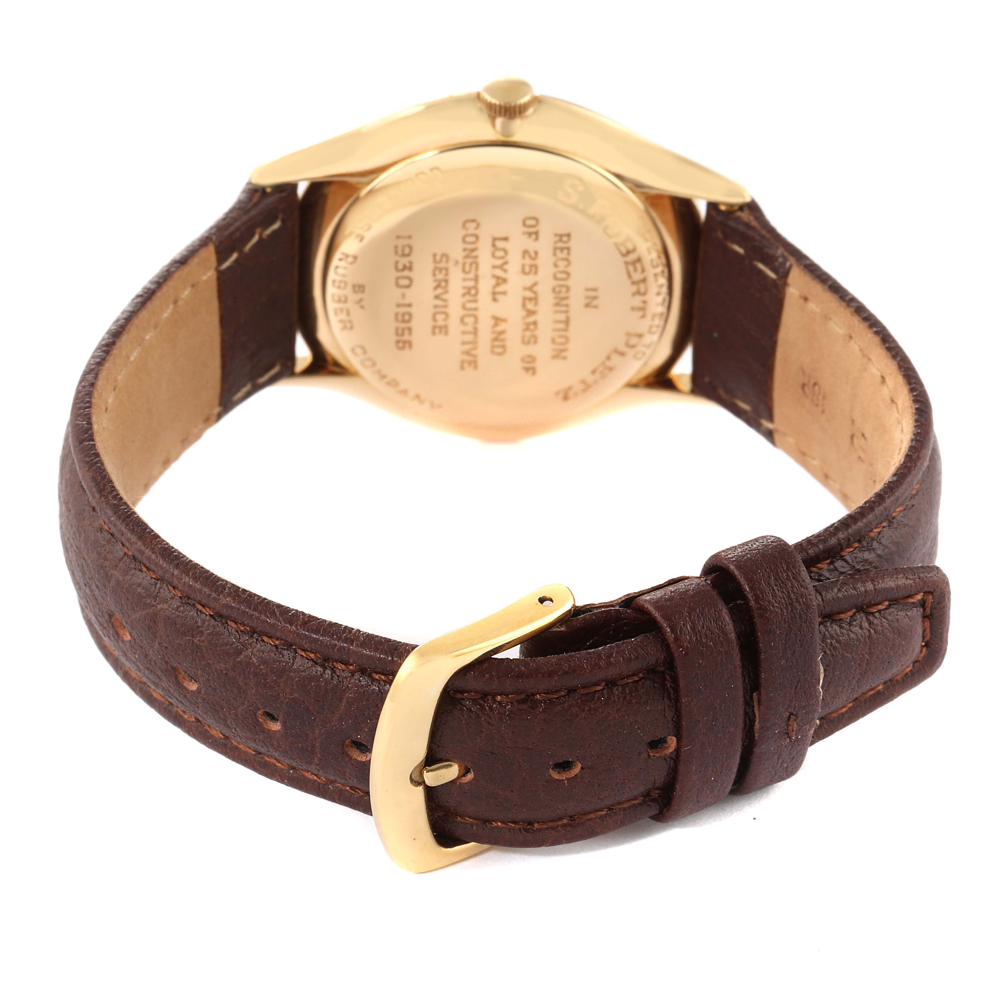 The image shows the back of a Patek Philippe Calatrava 2507 Men's Yellow Gold Silver Dial 2507 Men's Yellow Gold Silver Dial watch, focusing on the engraved case back and brown leather strap with a gold buckle.