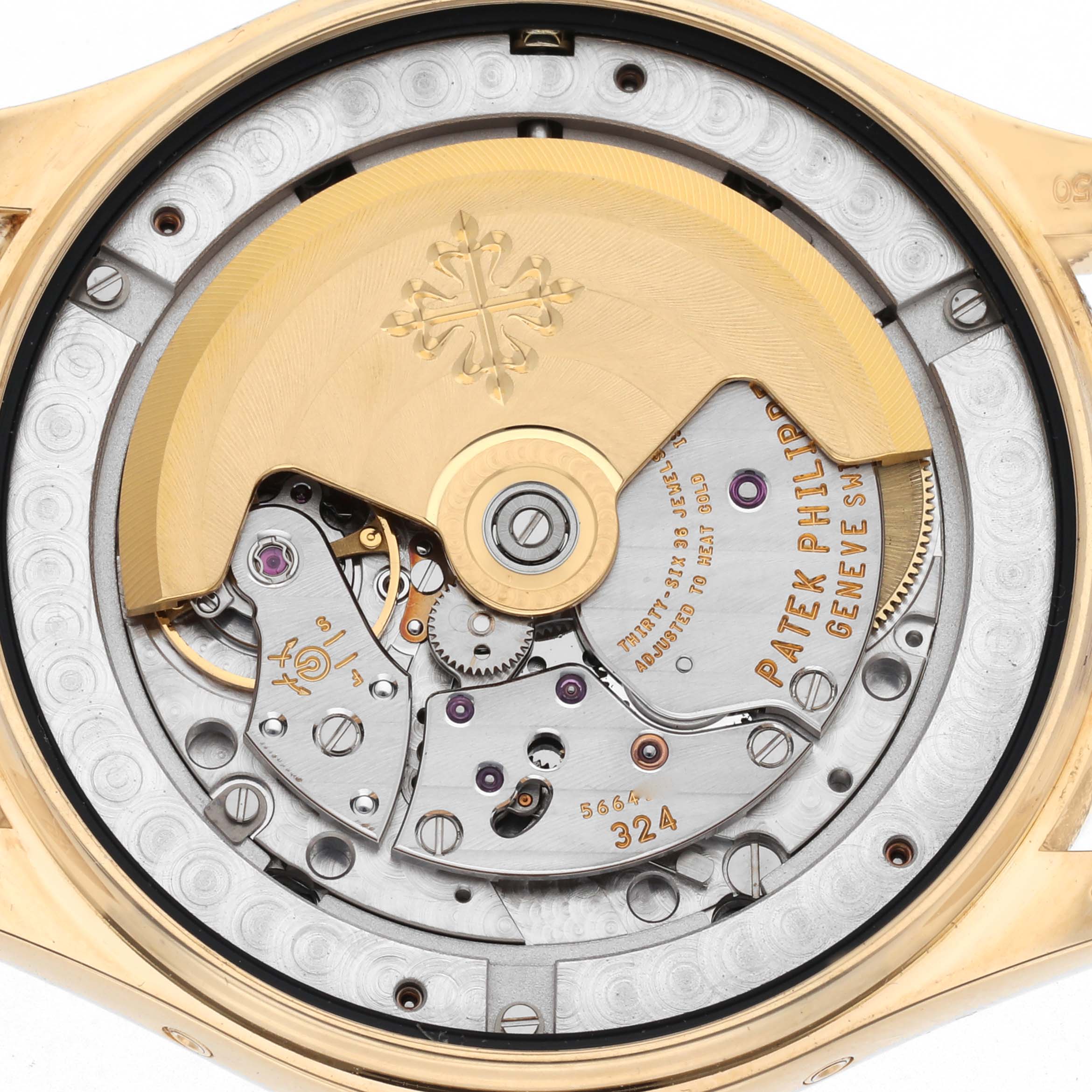 The image shows the Patek Philippe Complications 5146J Men's Yellow Gold Beige Dial 5146J Men's Yellow Gold Beige Dial watch's movement from the back, highlighting its intricate mechanisms and rotor.