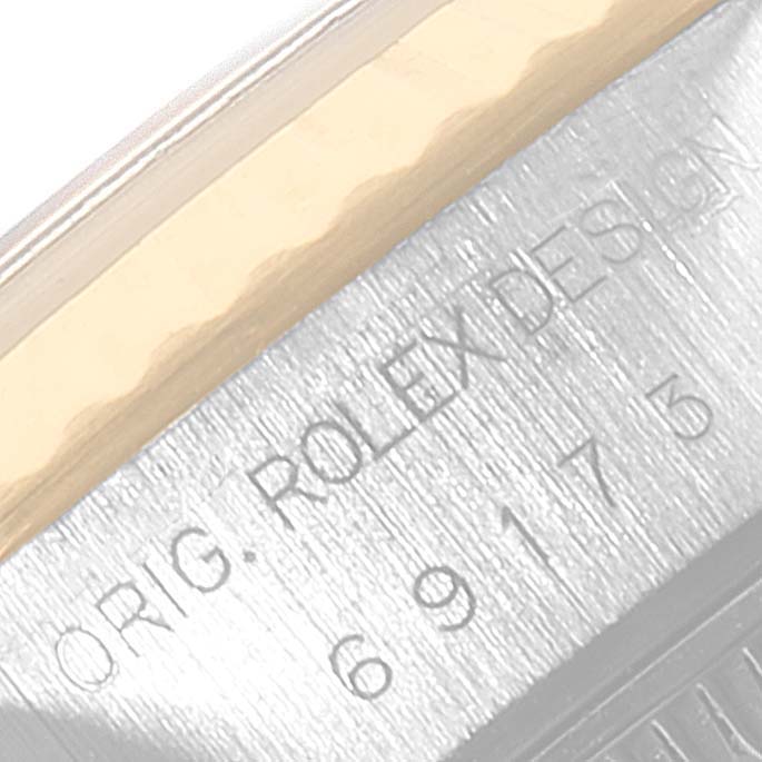 The image shows a close-up of the Rolex Datejust 69173 Women's Steel and Gold (two tone) White Dial 69173 Women's Steel and Gold (two tone) White Dial model's engraved serial number and the words "ORIG. ROLEX DESIGN".