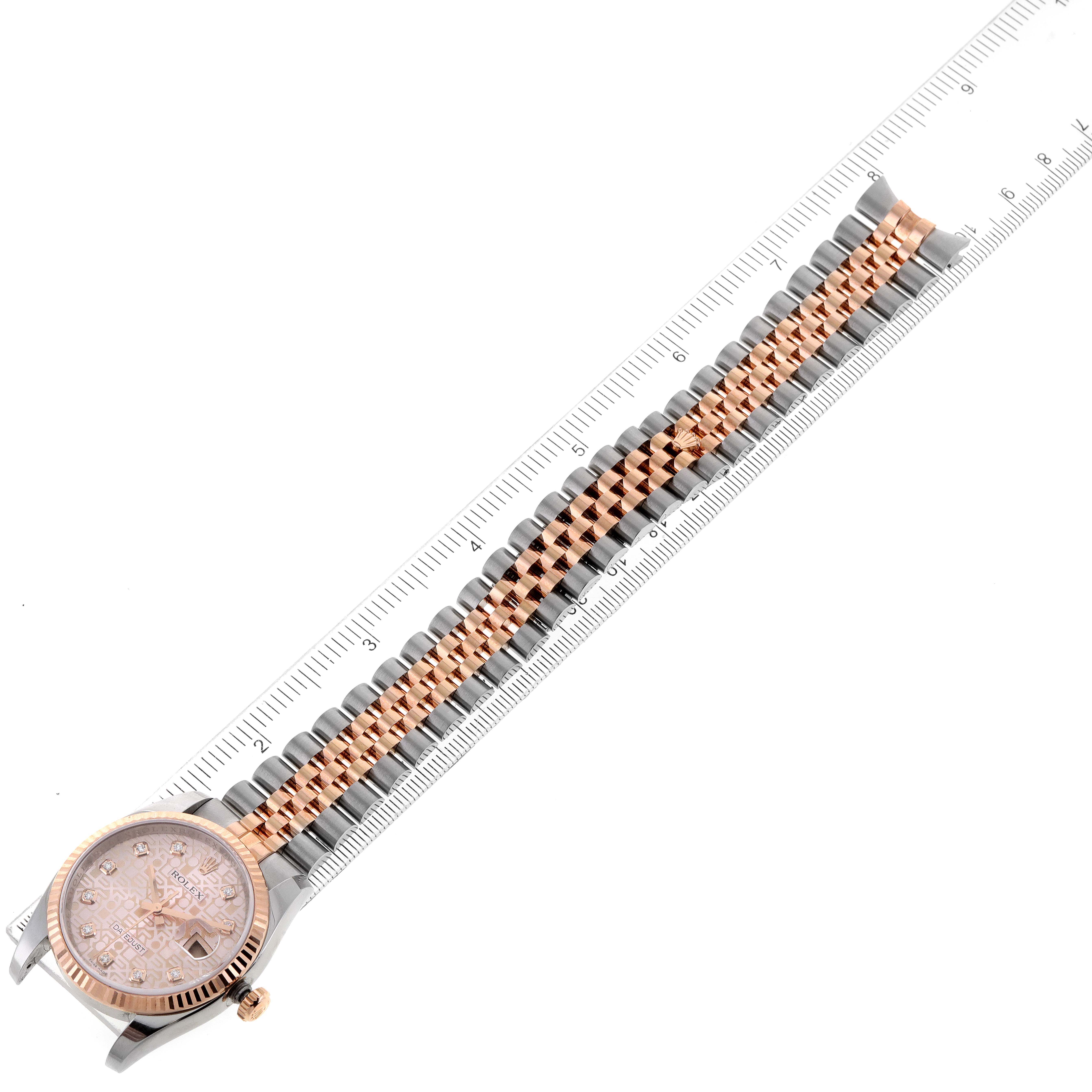 The Rolex Datejust 116231 Men's Steel and Gold (two tone) Pink Dial 116231 Men's Steel and Gold (two tone) Pink Dial watch is shown at a top-down angle, highlighting its dial, case, and two-tone bracelet against a ruler.