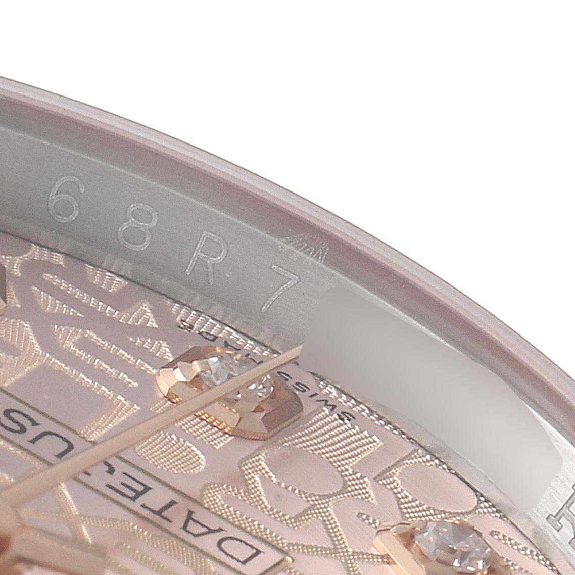 This close-up image of a Rolex Datejust 116231 Men's Steel and Gold (two tone) Pink Dial 116231 Men's Steel and Gold (two tone) Pink Dial watch shows the intricate details of the dial, indices with diamonds, and part of the rehaut with engraved serial numbers.