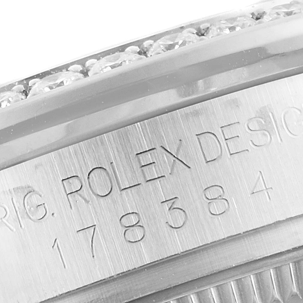 This close-up image shows the engraved case side and diamond-encrusted bezel of a Mid-Size Rolex watch.