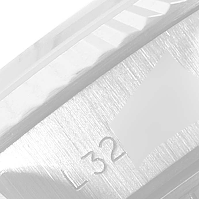 This is a close-up of the Rolex Datejust 69174 Women
s Stainless Steel Silver Dial 69174 Women
s Stainless Steel Silver Dial watch, showing part of its bezel and a section possibly having an engraved serial number starting with "L32."