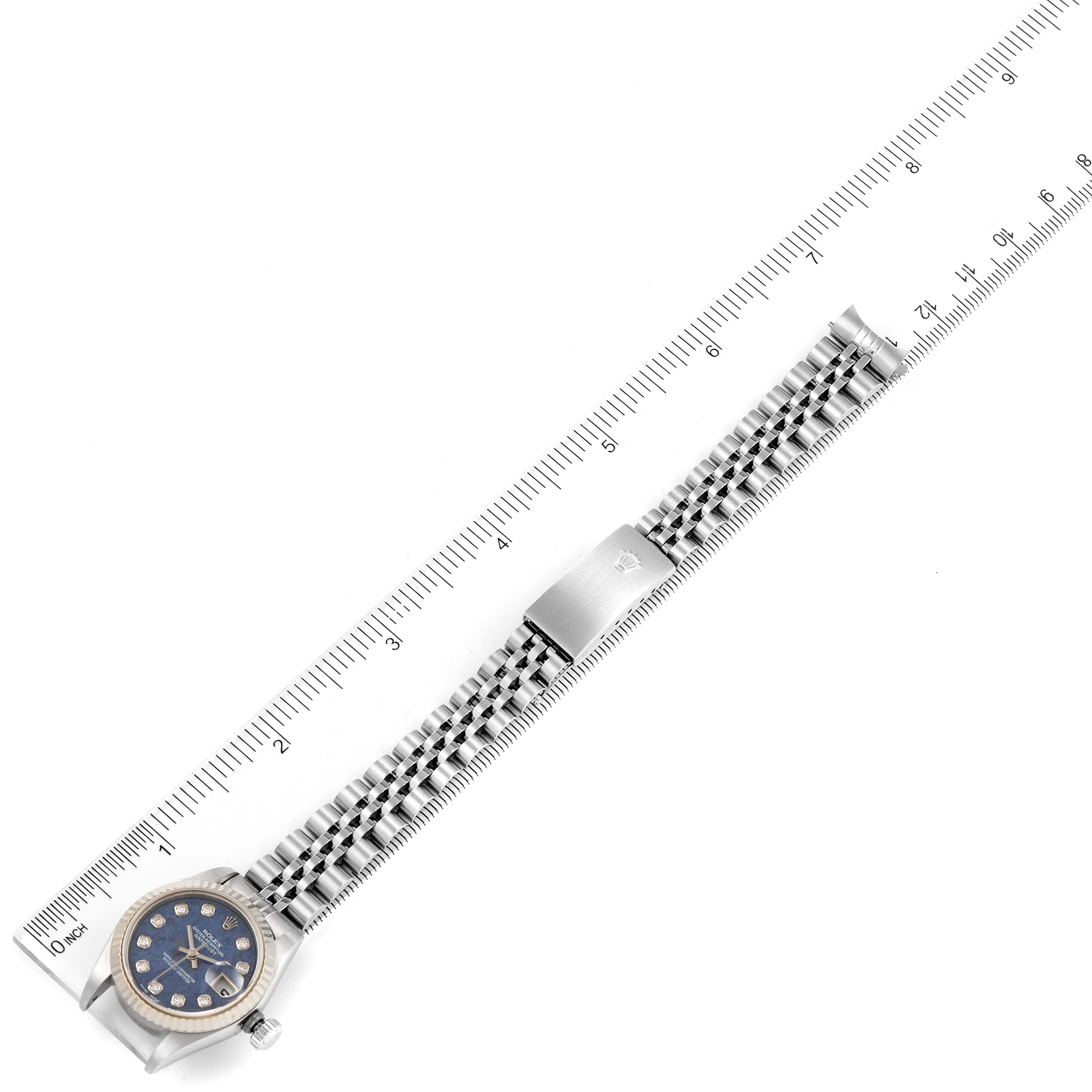 The image shows a Rolex Datejust 79174 Women's Stainless Steel Blue Dial 79174 Women's Stainless Steel Blue Dial watch laid flat with the full bracelet extended alongside a ruler for measurement.