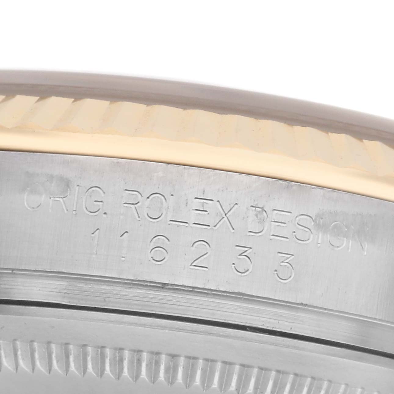 The image shows a close-up of the side of a Rolex Datejust 116233 Men's Steel and Gold (two tone) Silver Dial 116233 Men's Steel and Gold (two tone) Silver Dial watch, focusing on the model number engraving on the casing.
