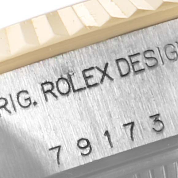 The image shows a close-up of the bezel and part of the case of a Rolex Datejust 79173 Women's Steel and Gold (two tone) Black Dial 79173 Women's Steel and Gold (two tone) Black Dial watch, also displaying some serial numbers.