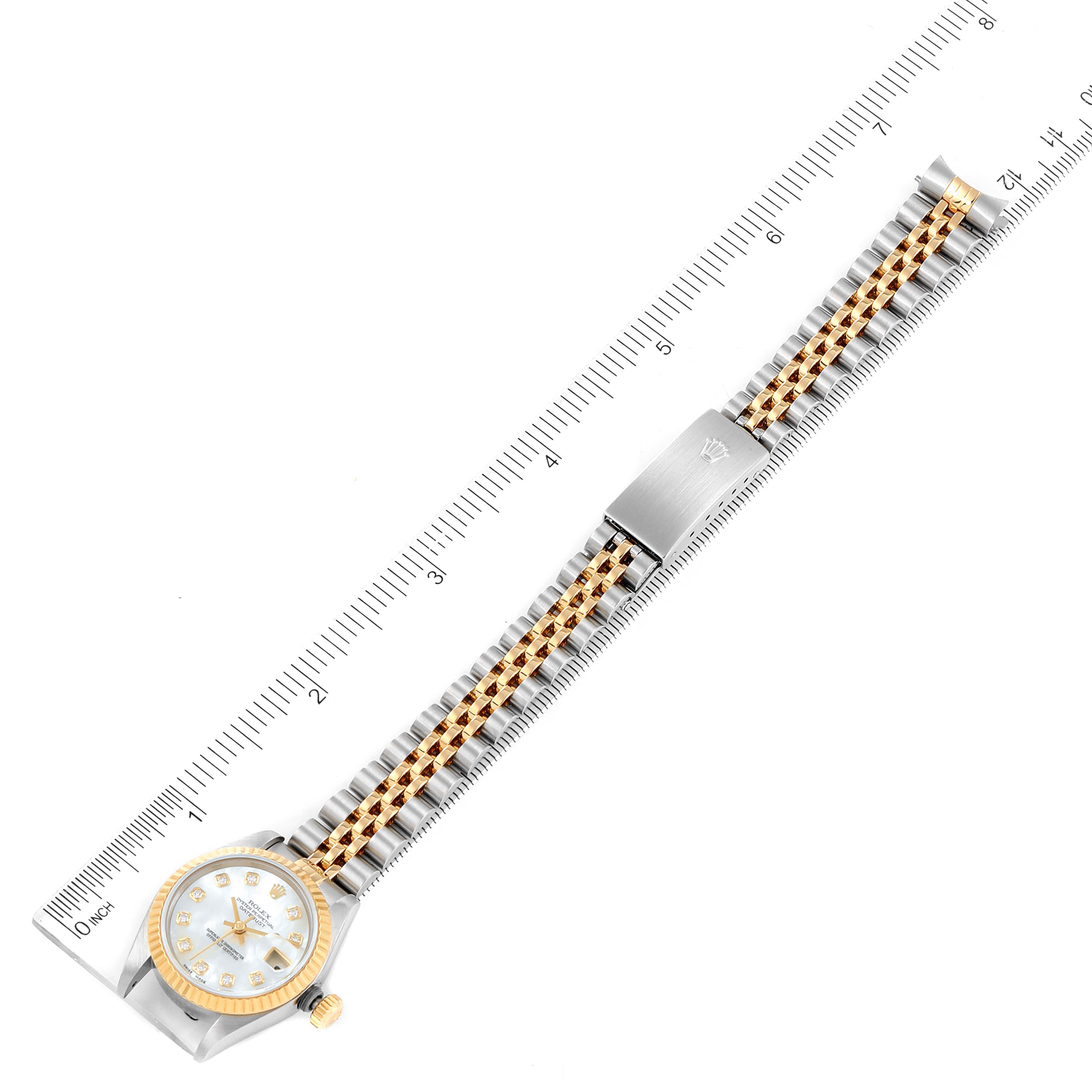 This image shows a top-down view of the Rolex Datejust 79173 Women's Steel and Gold (two tone) Mother of Pearl Dial 79173 Women's Steel and Gold (two tone) Mother of Pearl Dial watch, showcasing the dial, gold bezel, and two-tone bracelet alongside a measuring ruler.