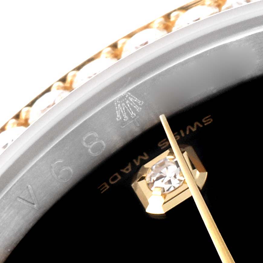 This image shows a close-up of the Rolex Datejust 116243 Men's Steel and Gold (two tone) Black Dial 116243 Men's Steel and Gold (two tone) Black Dial watch, specifically focusing on the bezel, part of the dial, and a diamond hour marker.