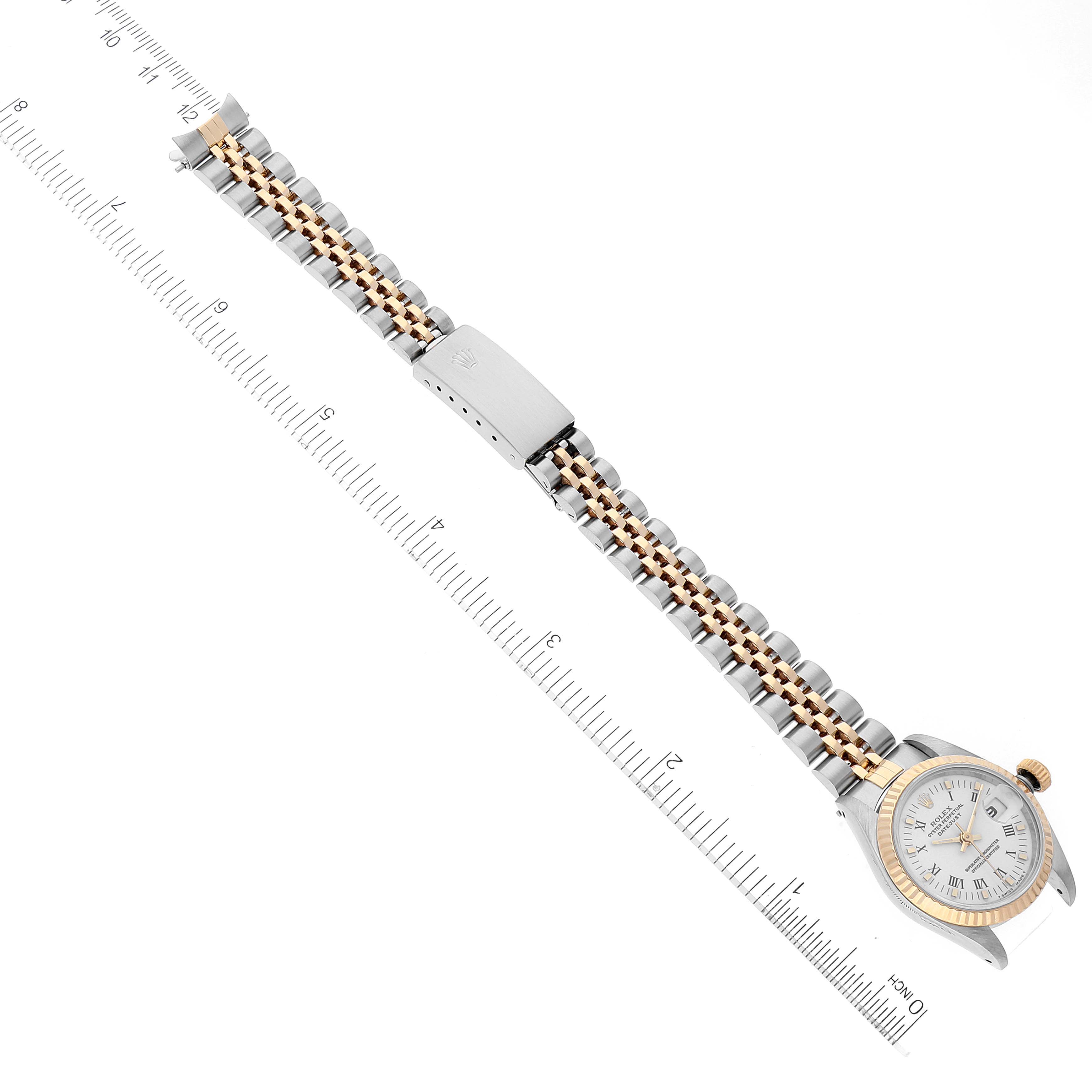 The image shows an overhead view of the Rolex Datejust 69173 Women
s Steel and Gold (two tone) White Dial 69173 Women
s Steel and Gold (two tone) White Dial watch with its band extended, laid next to a ruler for measurement.
