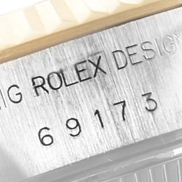 This close-up image shows the engraved serial number and "Rolex Design" text on the case of a Rolex Datejust 69173 Women's Steel and Gold (two tone) White Dial 69173 Women's Steel and Gold (two tone) White Dial model.