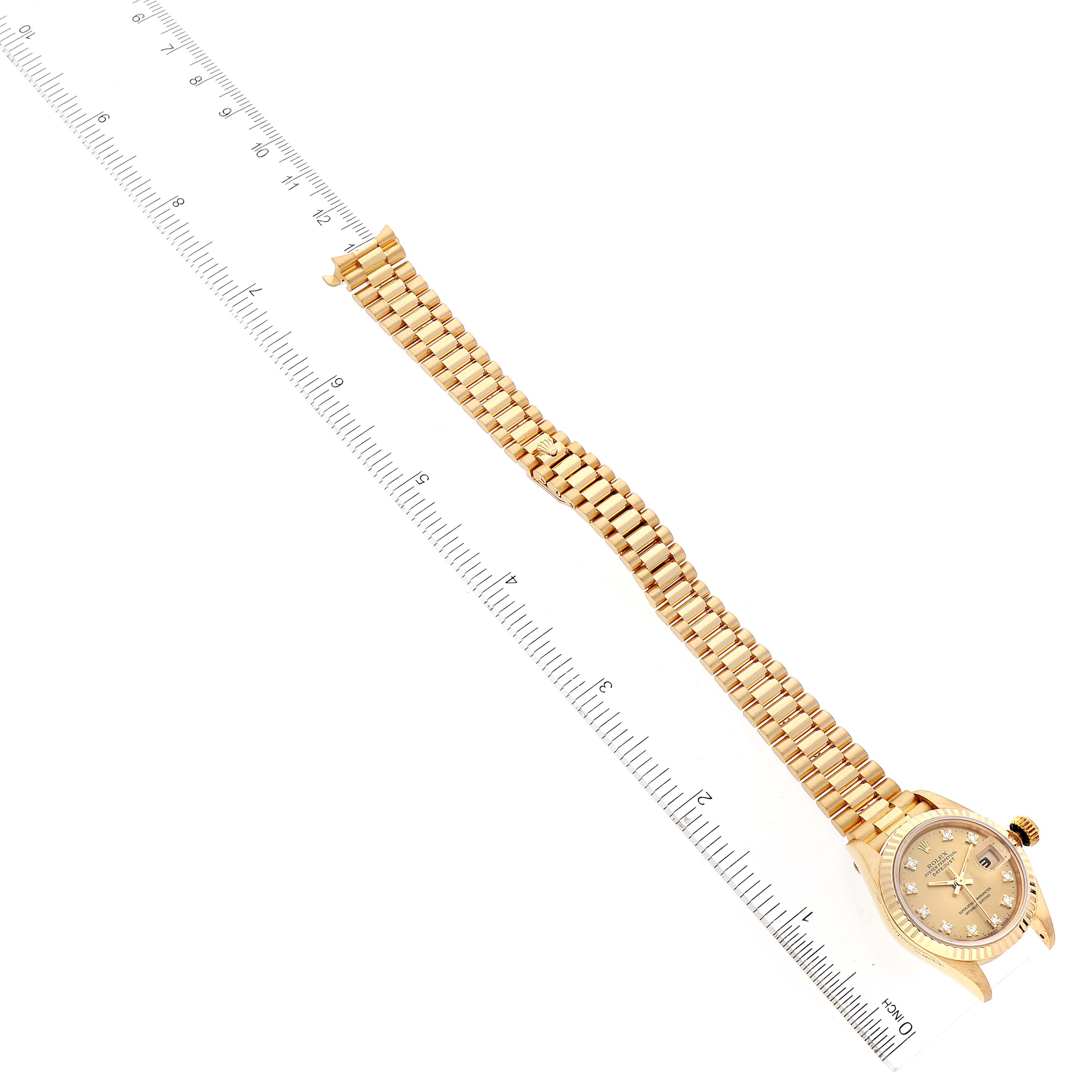 The image shows a Rolex President 69178 Women
s Yellow Gold Champagne Dial 69178 Women
s Yellow Gold Champagne Dial model watch at an angle, highlighting the watch case and bracelet alongside a ruler for scale.
