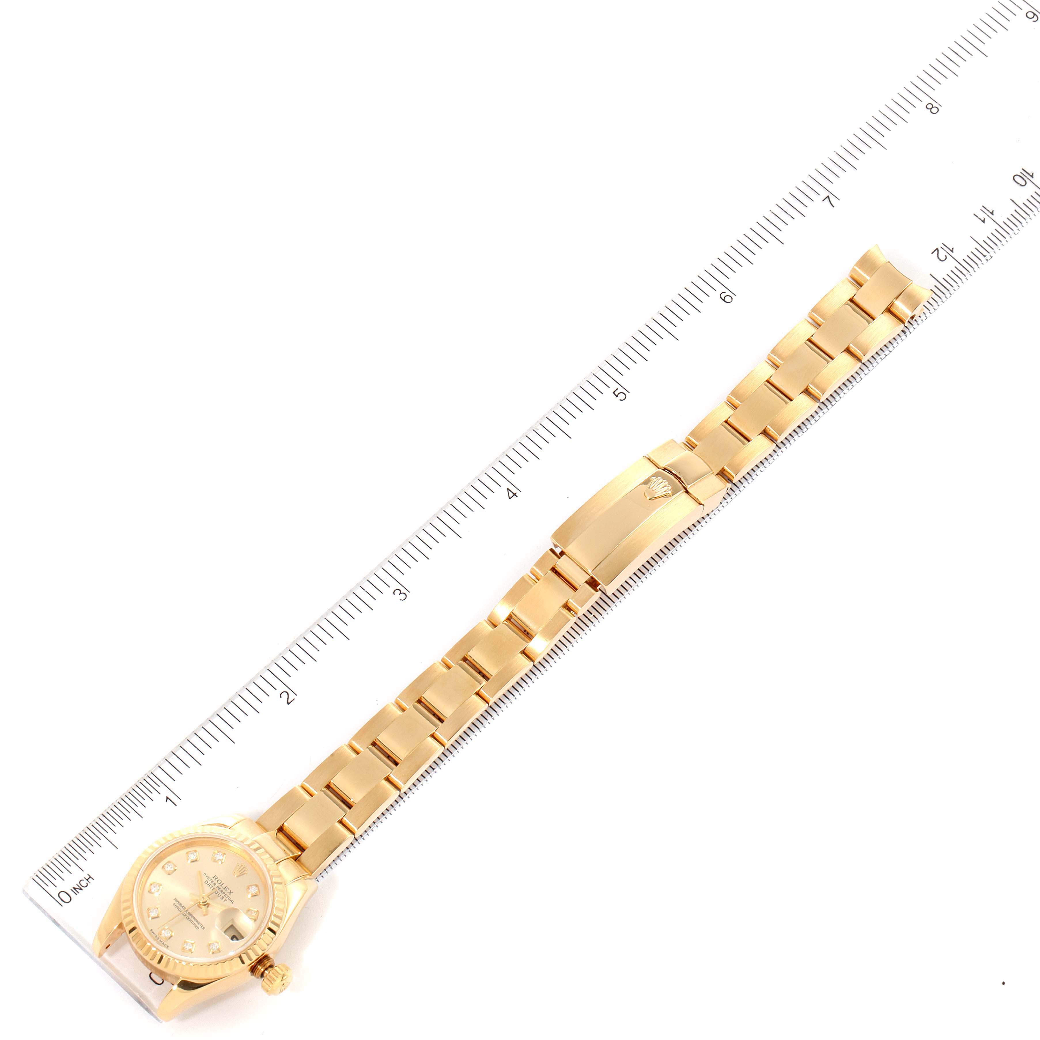 The image shows a Rolex President 179178 Women
s Yellow Gold Champagne Dial 179178 Women
s Yellow Gold Champagne Dial model watch laid flat aligned with a ruler for measurement, displaying the full bracelet and dial face.