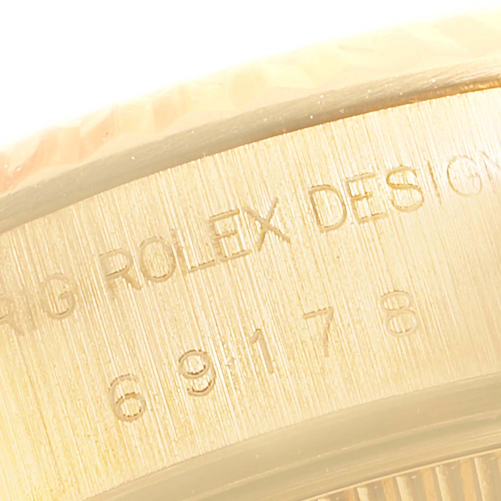 This close-up image shows the engraved side of the bezel on a Rolex President 69178 Women's Yellow Gold Champagne Dial 69178 Women's Yellow Gold Champagne Dial model watch.