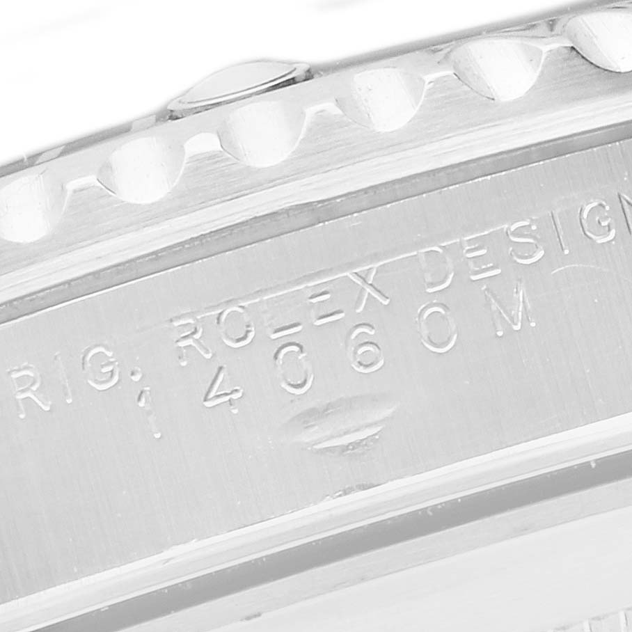 The image shows a close-up of the Rolex Submariner 14060M Men's Stainless Steel Black Dial 14060M Men's Stainless Steel Black Dial's side engraving and part of the bezel.