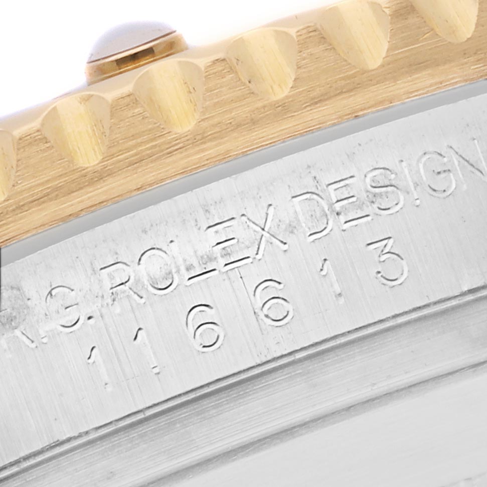 The image shows a close-up of the Rolex Submariner 116613 Men's Steel and Gold (two tone) Blue Dial 116613 Men's Steel and Gold (two tone) Blue Dial's bezel and engraved case edge, highlighting the model number.