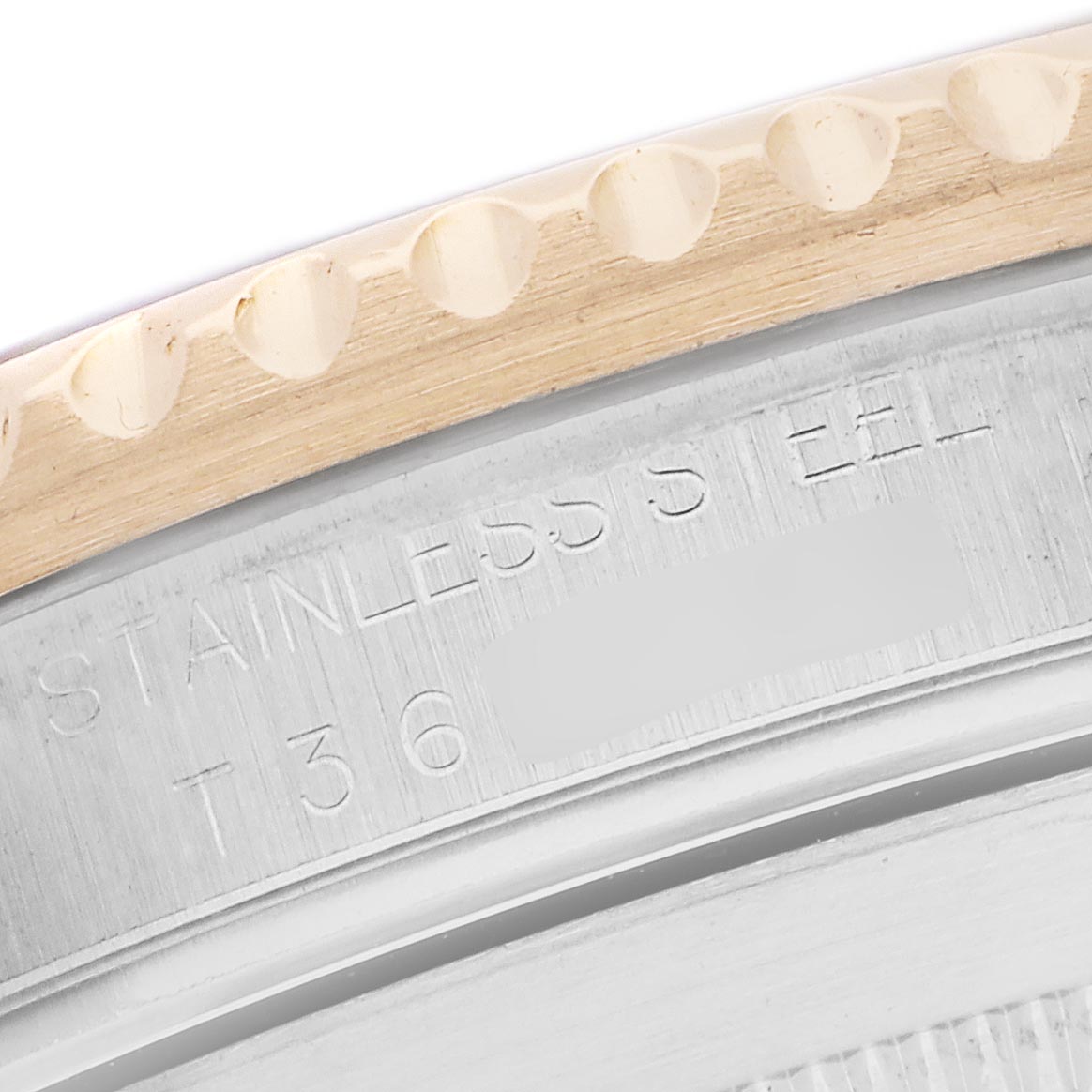 The image shows a close-up of the Rolex Submariner 16613 Men
s Steel and Gold (two tone) Silver Dial 16613 Men
s Steel and Gold (two tone) Silver Dial
s case back with engraved text and part of the serrated edge bezel.