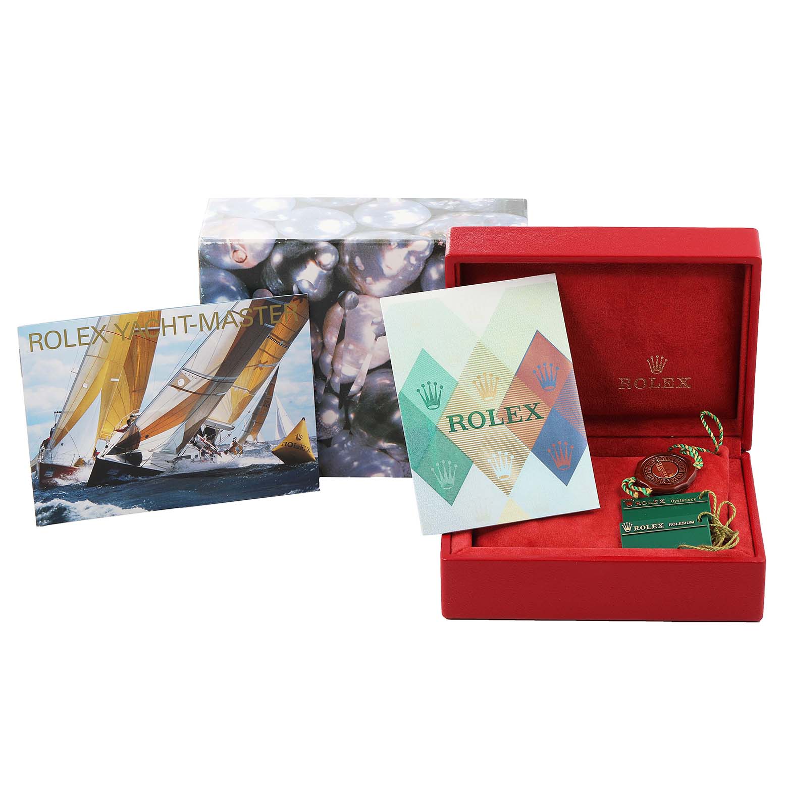 This image shows a Rolex Yacht-Master 169622 Women
s Stainless Steel Silver Dial 169622 Women
s Stainless Steel Silver Dial packaging with a red box, brochure, and accessories like a green tag and coin.