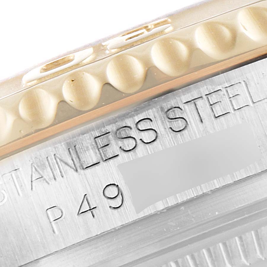 This close-up image of a Rolex Yacht-Master 168623 Women's Steel and Gold (two tone) Grey Dial 168623 Women's Steel and Gold (two tone) Grey Dial watch shows part of the bezel and the "STAINLESS STEEL" engraving on the case.