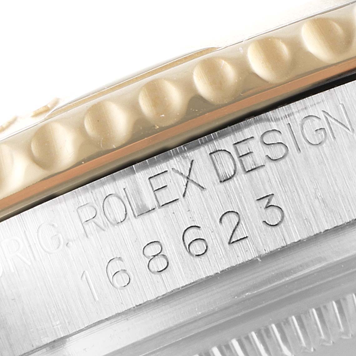 The image shows a close-up of the edge of the bezel and engraved markings on the case of a Rolex Yacht-Master 168623 Women's Steel and Gold (two tone) Grey Dial 168623 Women's Steel and Gold (two tone) Grey Dial watch.