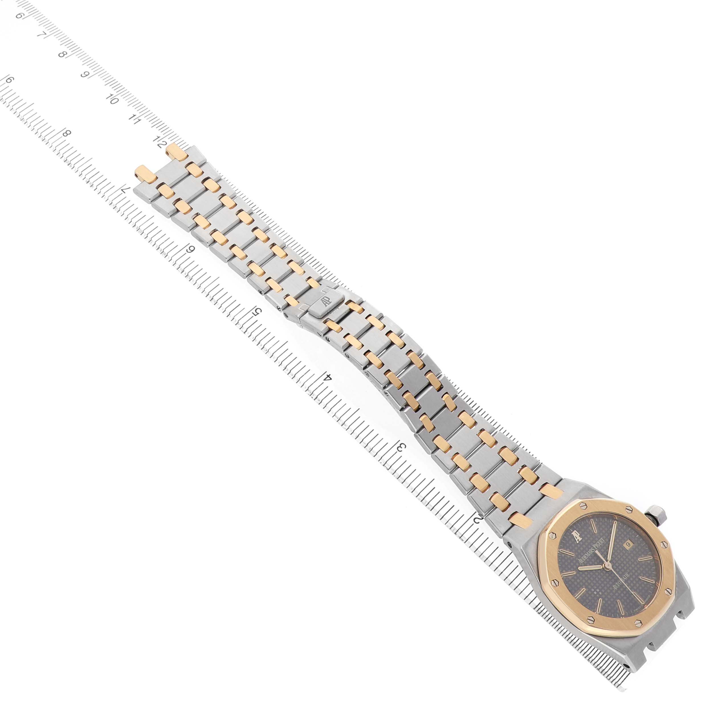 The Audemars Piguet Royal Oak 15000SA Men's Steel and Gold (two tone) Grey Dial watch is shown from a top view, displaying its full bracelet and face alongside a ruler.