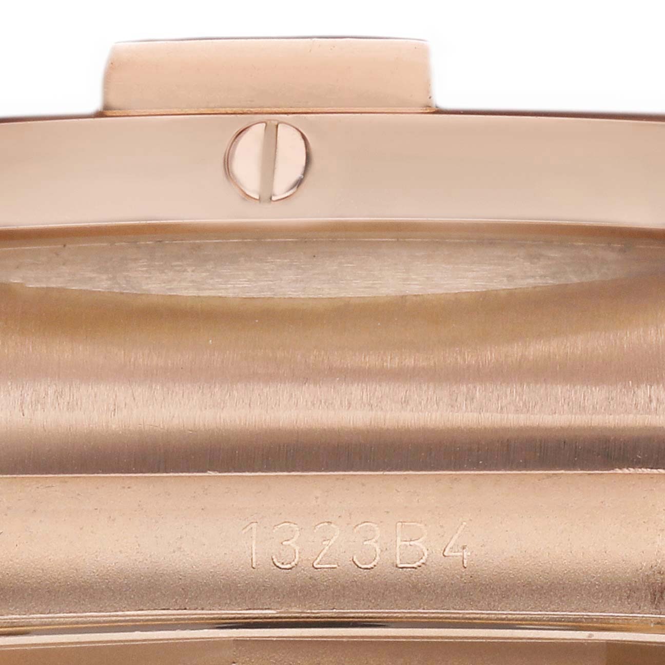 The image shows a close-up of the clasp or part of the bracelet for the Breitling Chronomat RB0136 Men's Rose Gold Blue Dial RB0136 Men's Rose Gold Blue Dial watch, featuring a screw and model number.