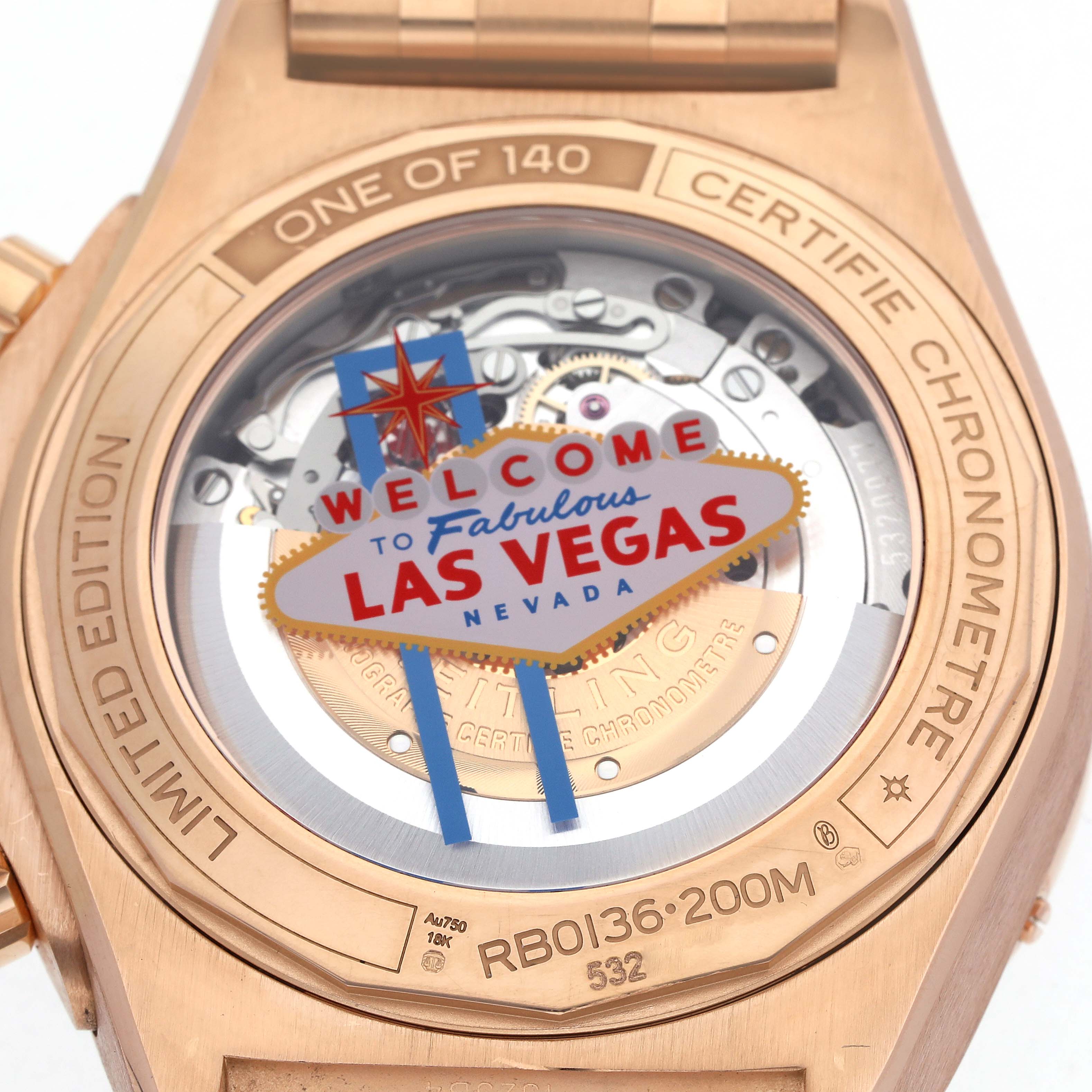 The image shows the case back of a Breitling Chronomat RB0136 Men's Rose Gold Blue Dial RB0136 Men's Rose Gold Blue Dial, featuring a Las Vegas-themed design and visible rotor.