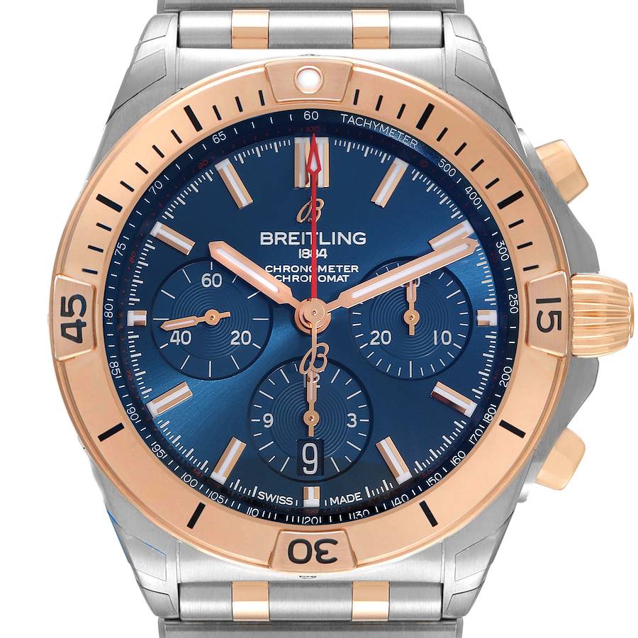 The image shows a Breitling Chronomat watch from a front angle, highlighting its blue dial, rose gold bezel, and chronograph subdials.