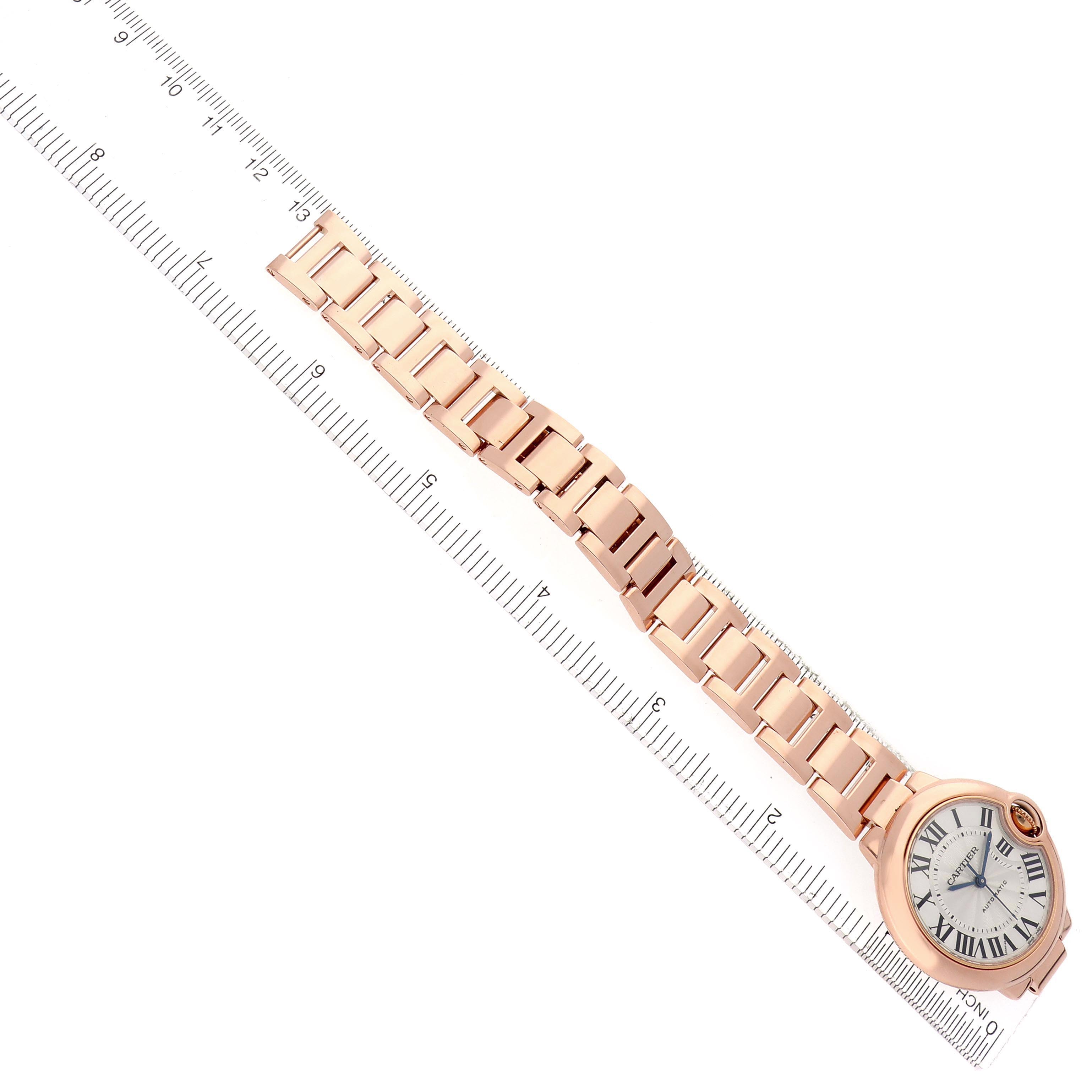 The image shows a Cartier Ballon Bleu W6920096 Women's Rose Gold Red Dial W6920096 Women's Rose Gold Red Dial watch at an angle, with its face and full bracelet aligned along a ruler.