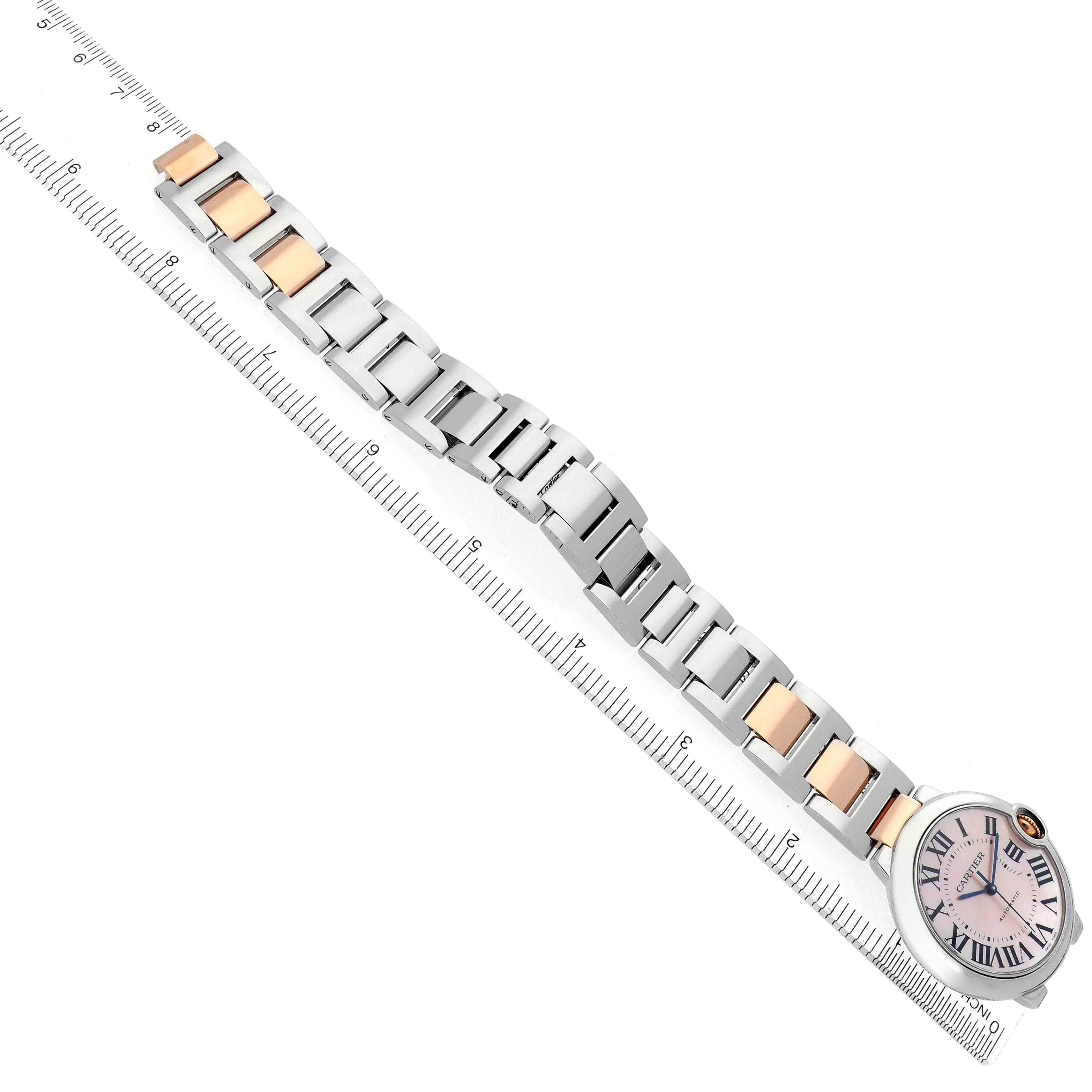 The Cartier Ballon Bleu W6920033 Women's Steel and Gold (two tone) Mother of Pearl Dial W6920033 Women's Steel and Gold (two tone) Mother of Pearl Dial watch is shown from a top view, displaying the bracelet and dial alongside a ruler for scale.
