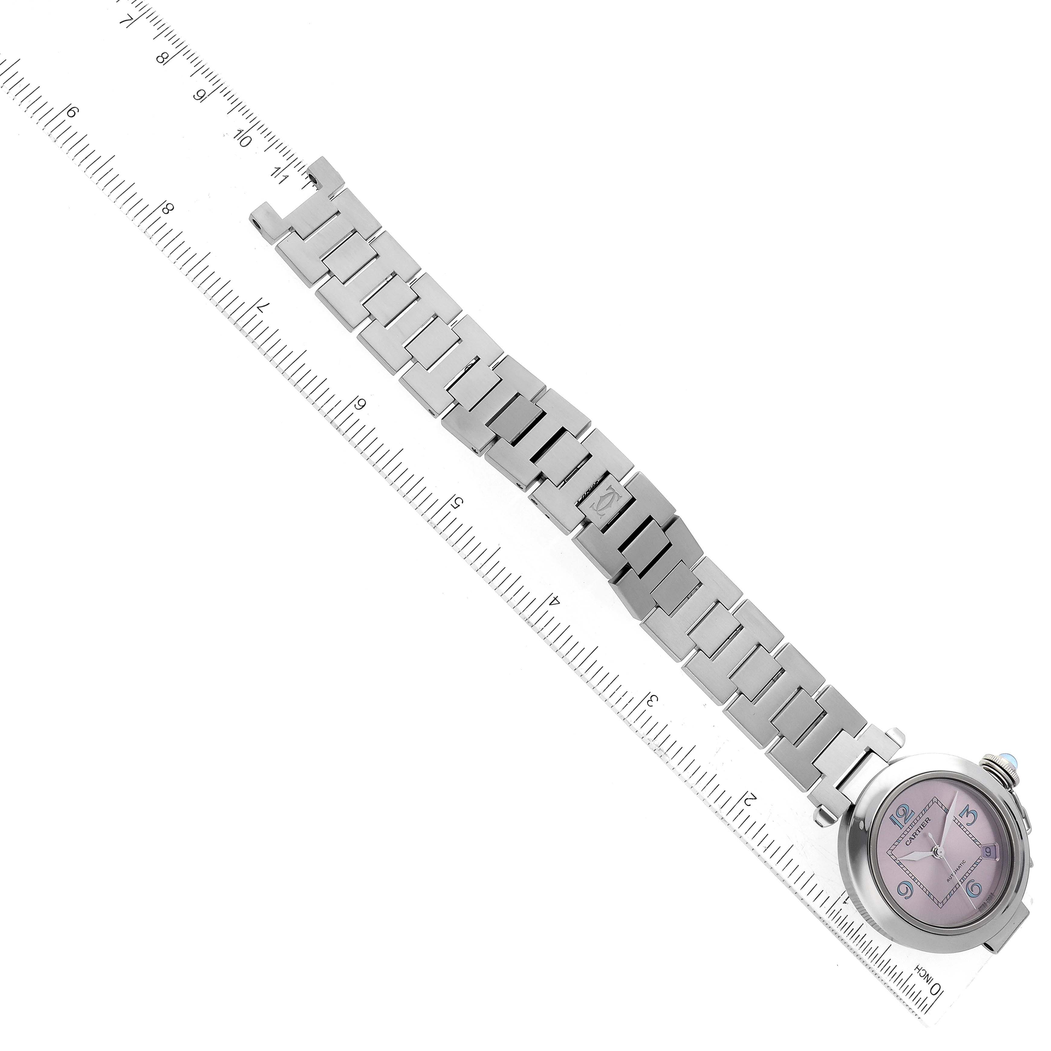 The image shows a Cartier Pasha W3108199 Women
s Stainless Steel Pink Dial W3108199 Women
s Stainless Steel Pink Dial watch laying flat with a view of the dial and metal bracelet, alongside a ruler for scale.