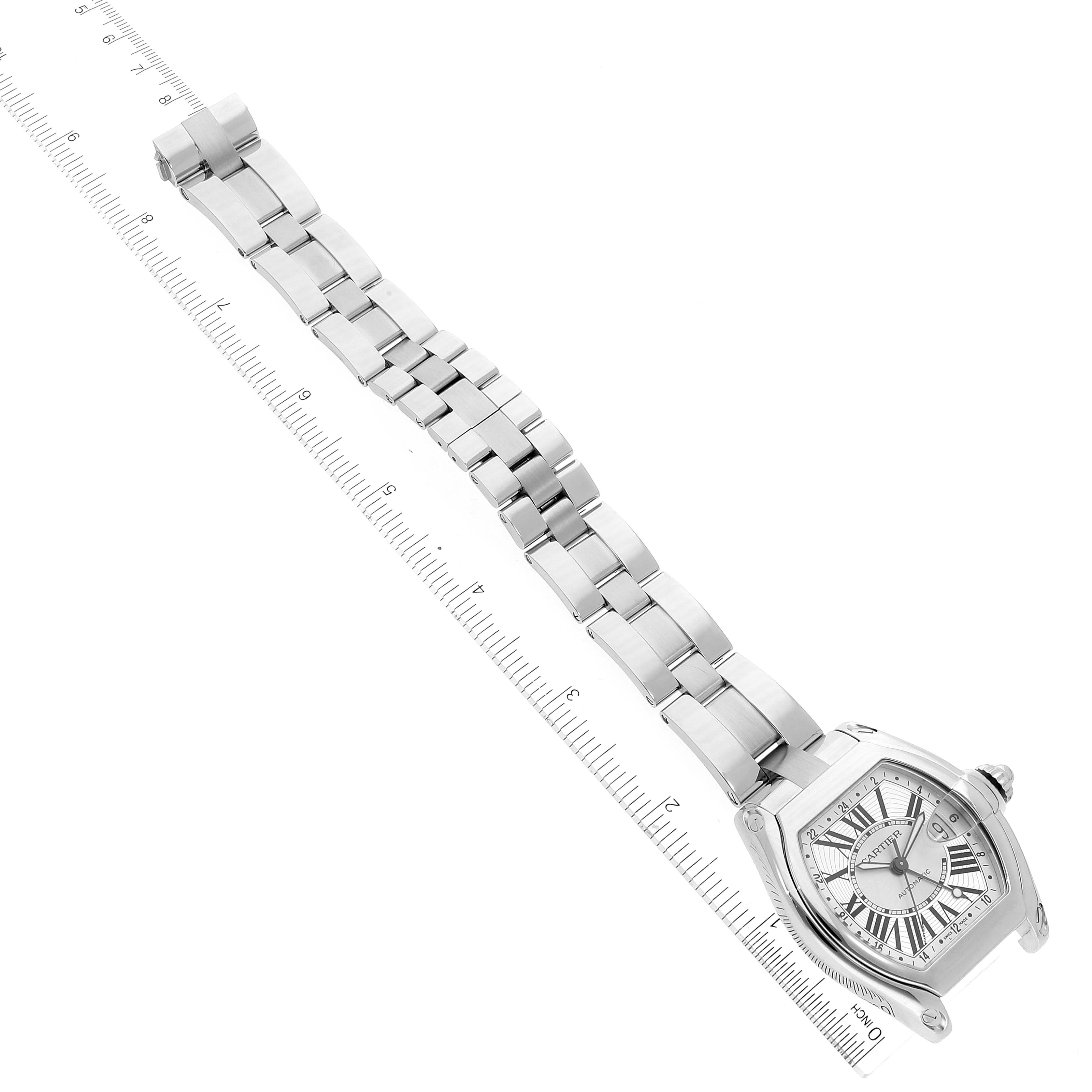 The image shows a Cartier Roadster W62032X6 Men's Stainless Steel Silver Dial W62032X6 Men's Stainless Steel Silver Dial watch model at an angle, displaying the watch face and metal bracelet next to a ruler.