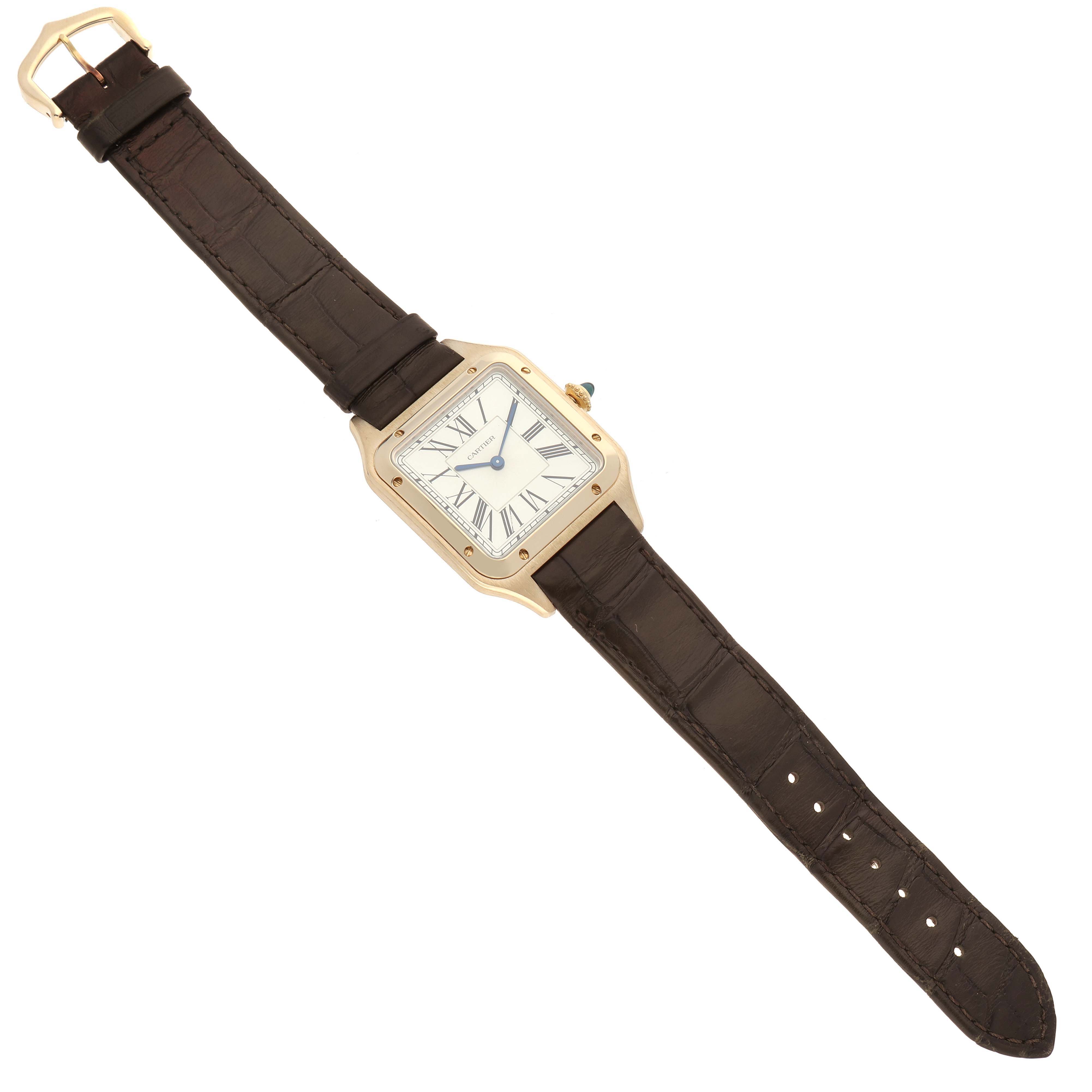 The Cartier Santos Dumont WGSA0027 Men's Yellow Gold Silver Dial WGSA0027 Men's Yellow Gold Silver Dial watch is shown from a top-down view, displaying the face, case, and brown leather strap.